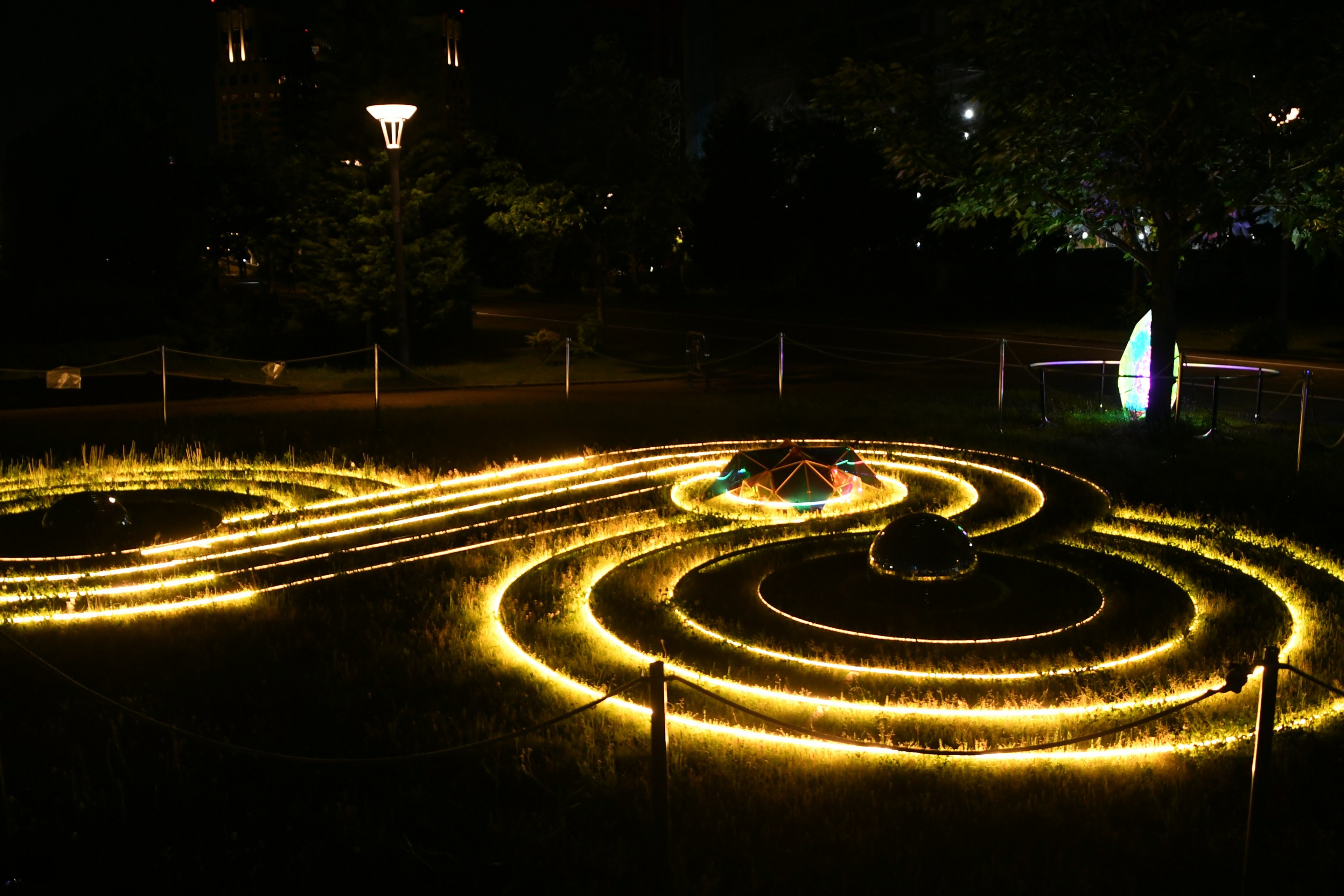 Leuchtende Spiralwege in einem dunklen Park bei Nacht