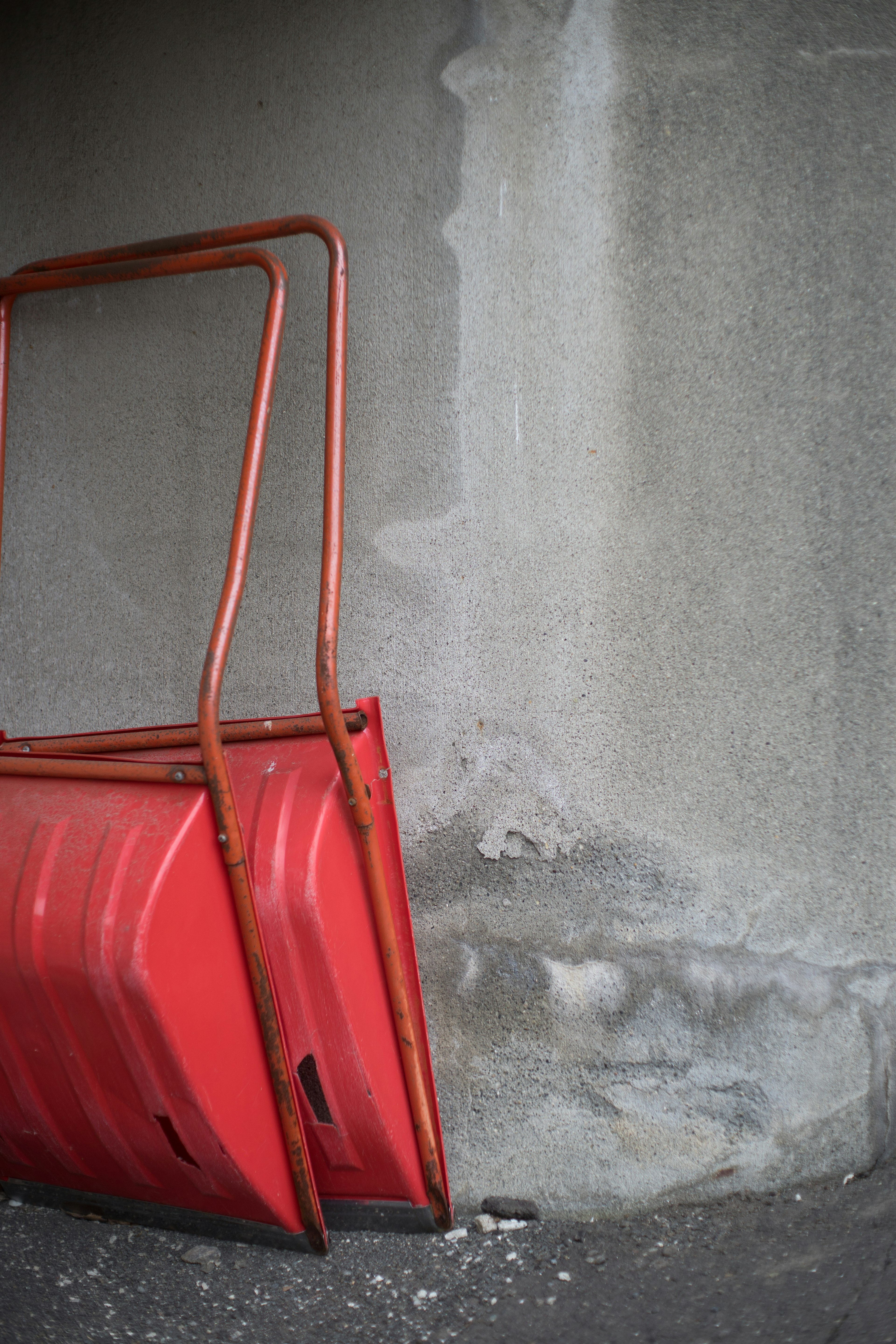 Barrage rouge adossé à un mur gris