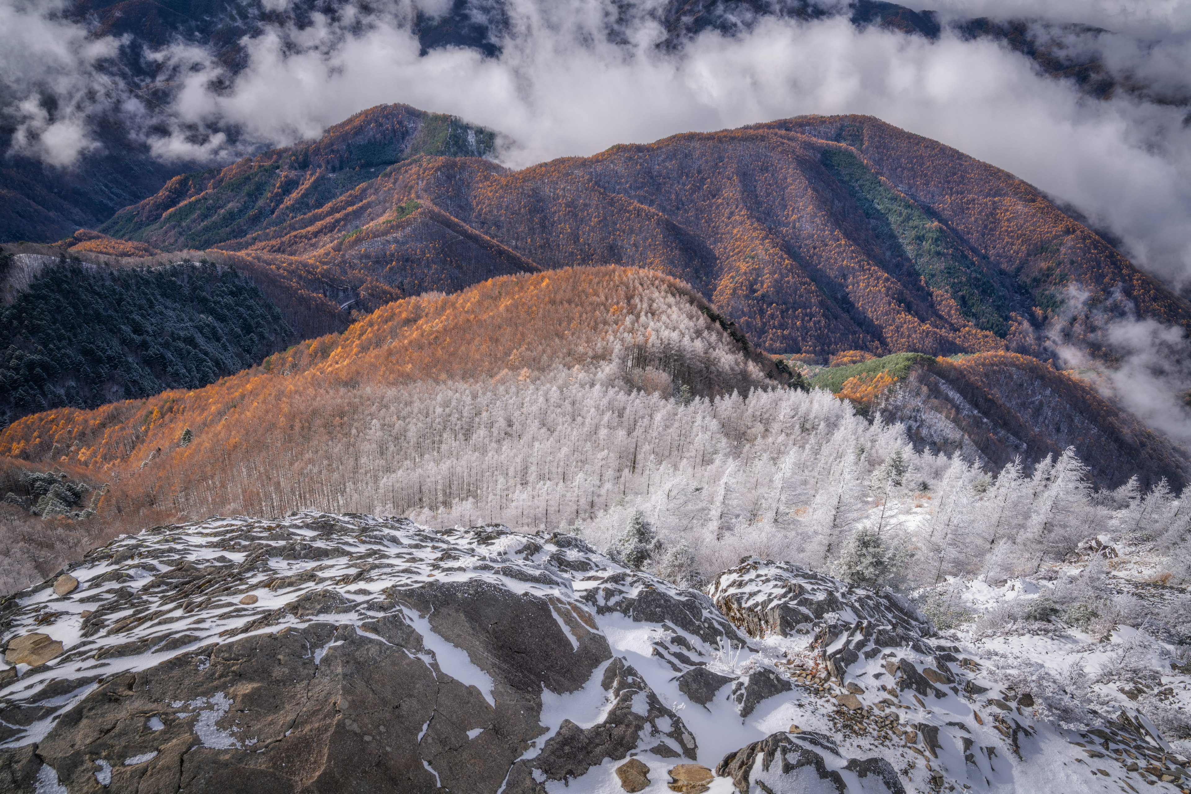 雪に覆われた山脈と雲の間から見える景色