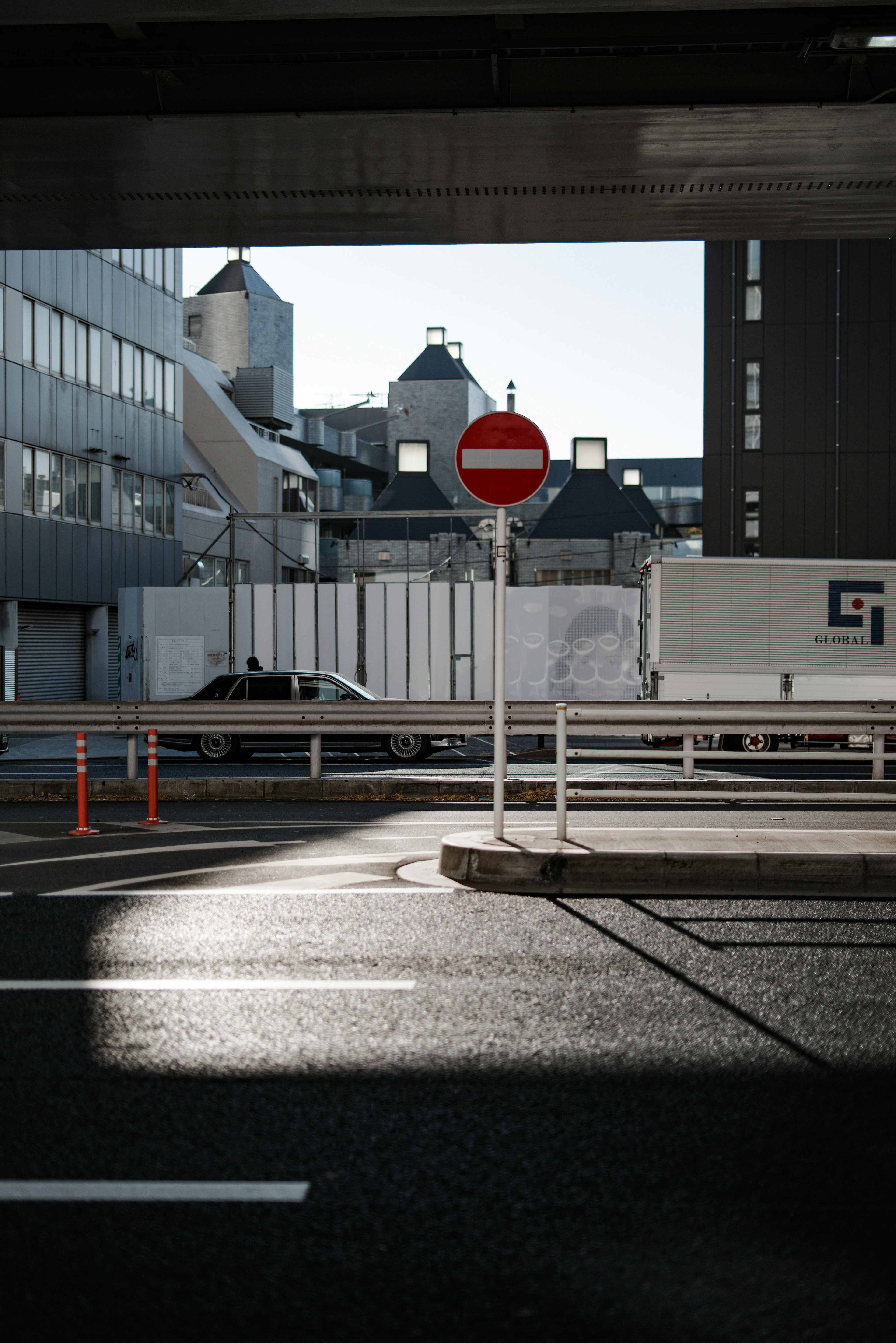 光が反射する道路と禁止標識がある都市の風景