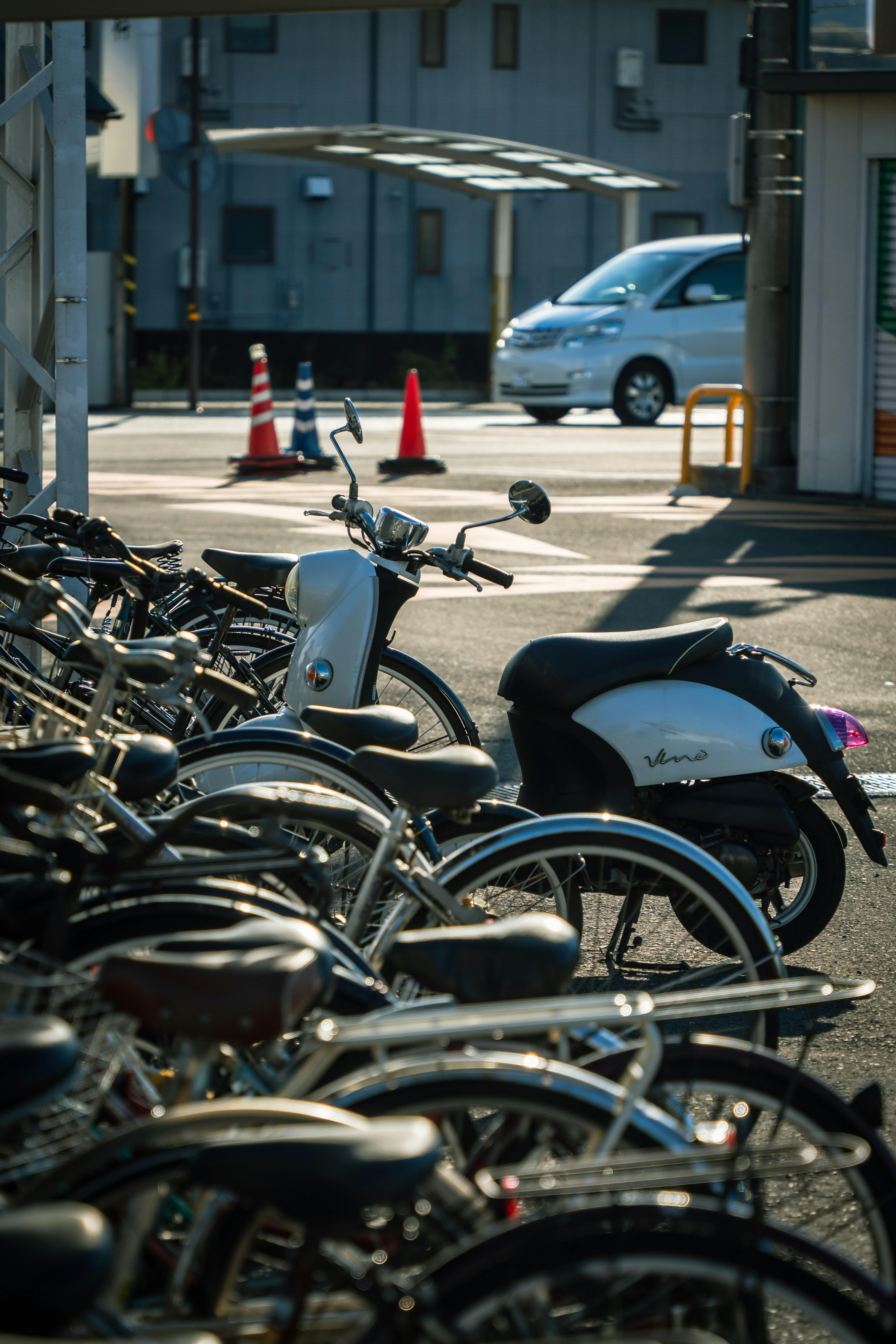 Area di parcheggio per biciclette con biciclette parcheggiate e una macchina bianca sulla strada