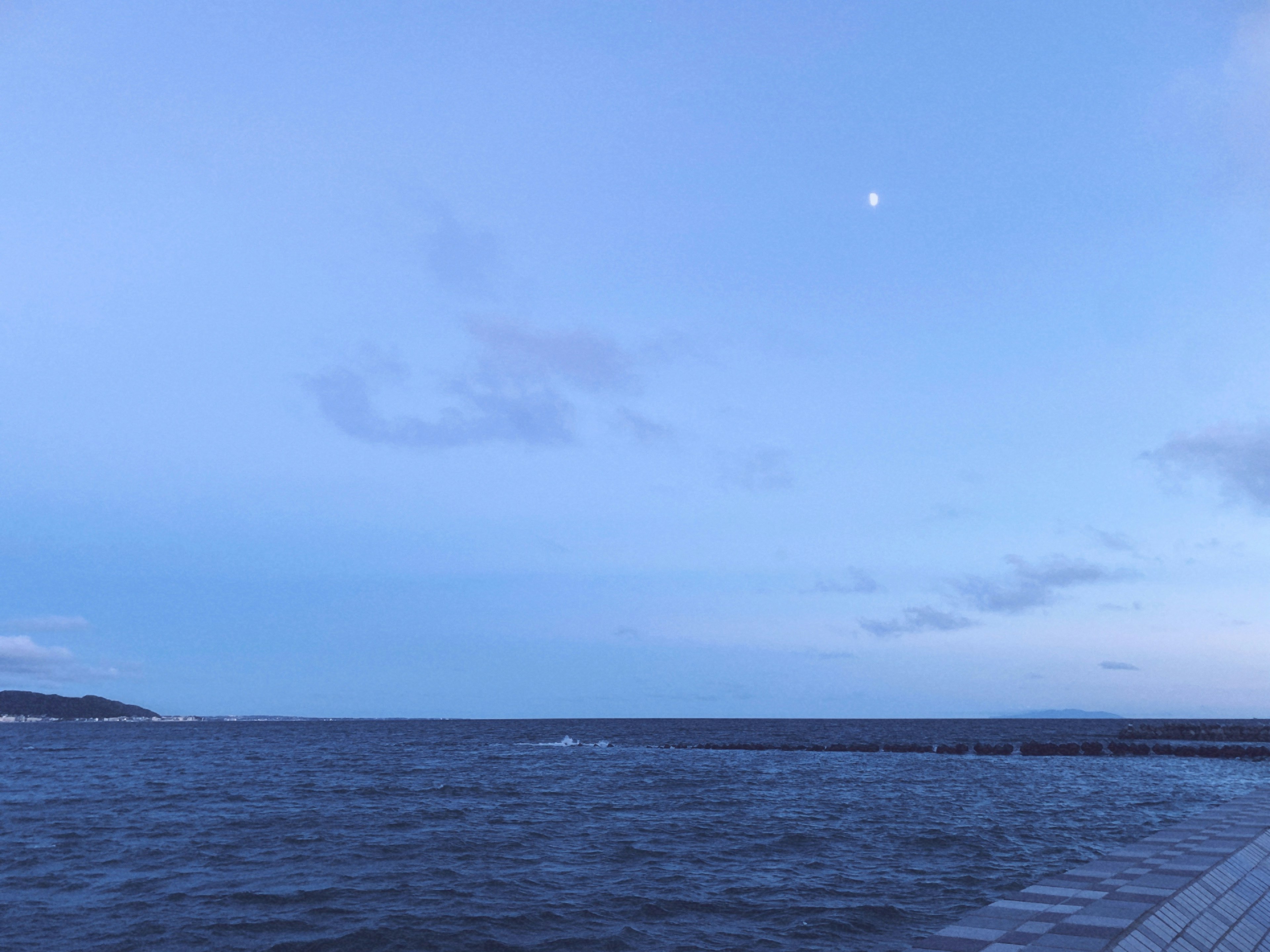 青い空と海の風景月が輝いている