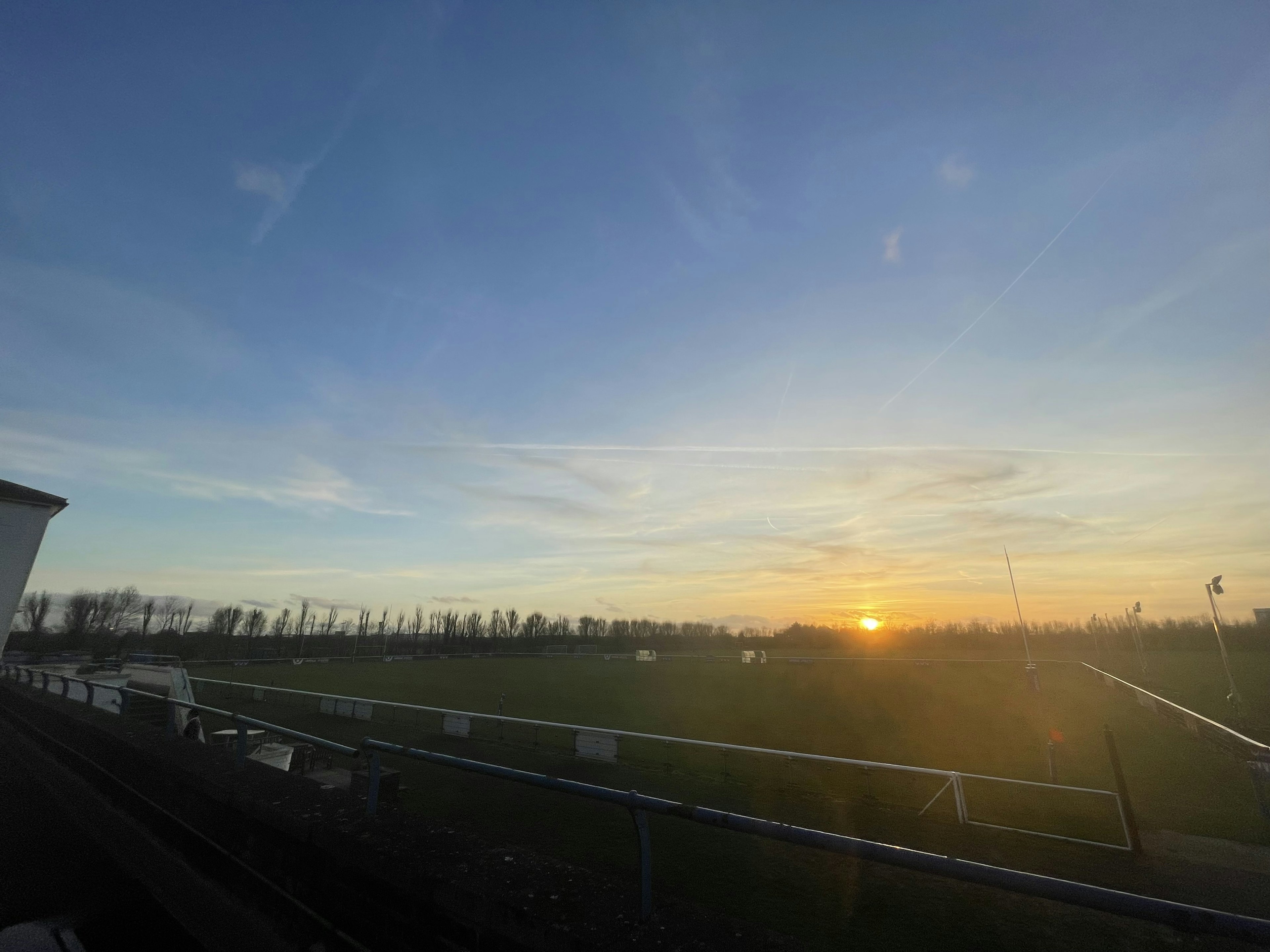 Sonnenuntergang über einem weiten Feld mit Wolken