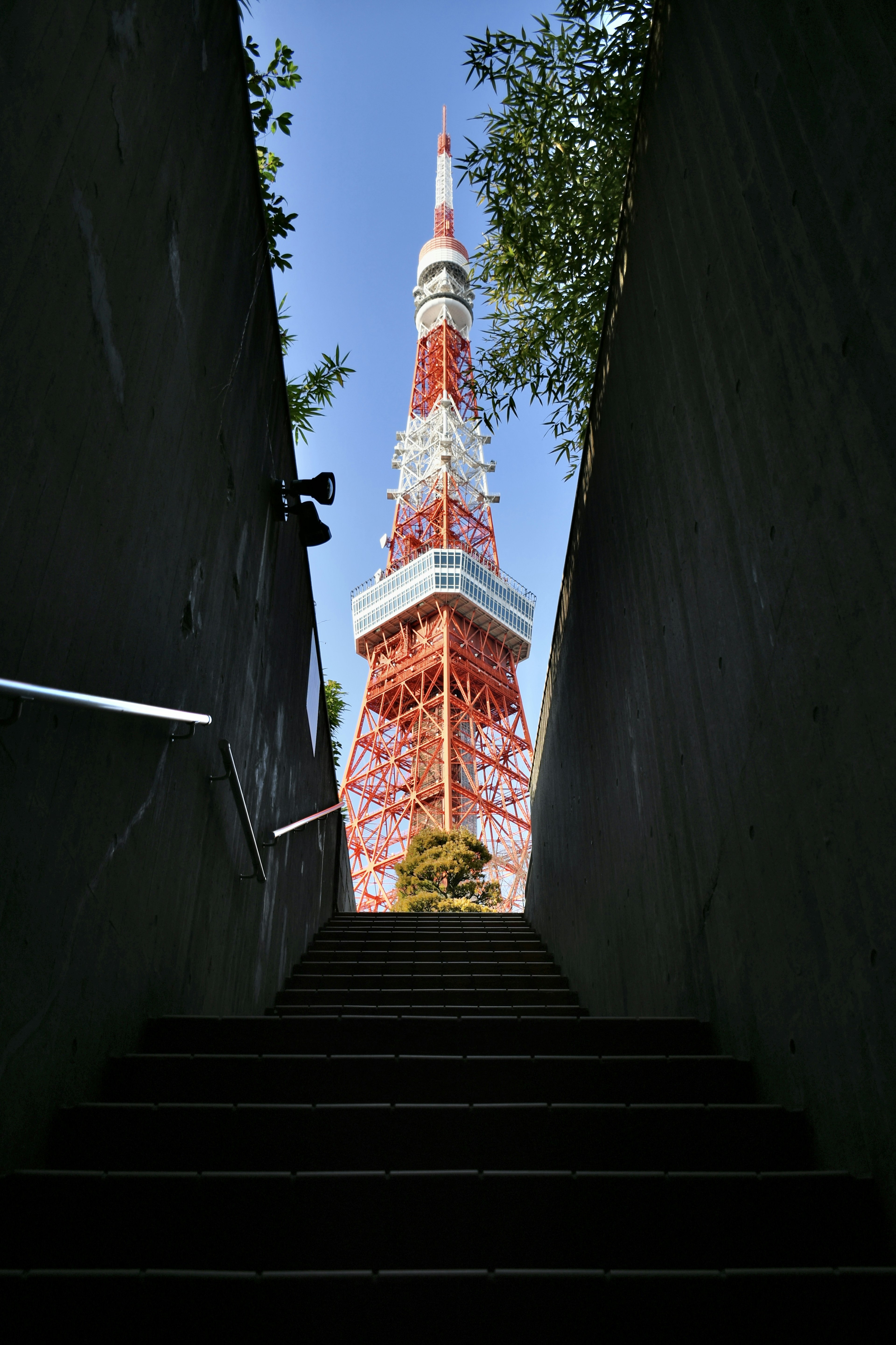 Blick auf den Tokyo Tower von der Unterseite der Treppe mit seiner lebhaften roten und weißen Struktur