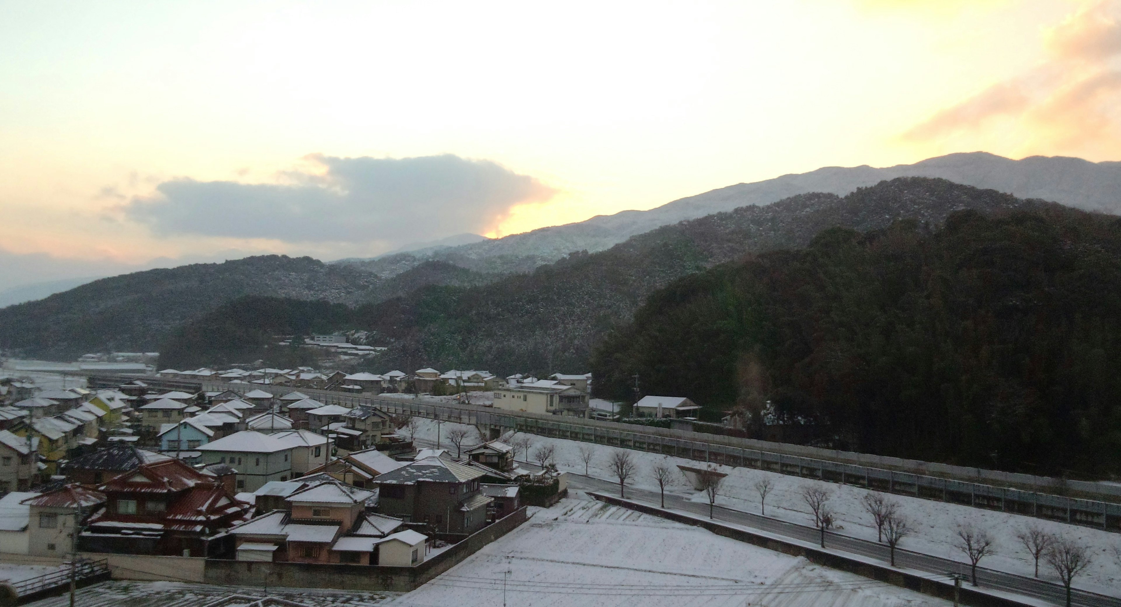 Snow-covered village landscape with silhouette of mountains