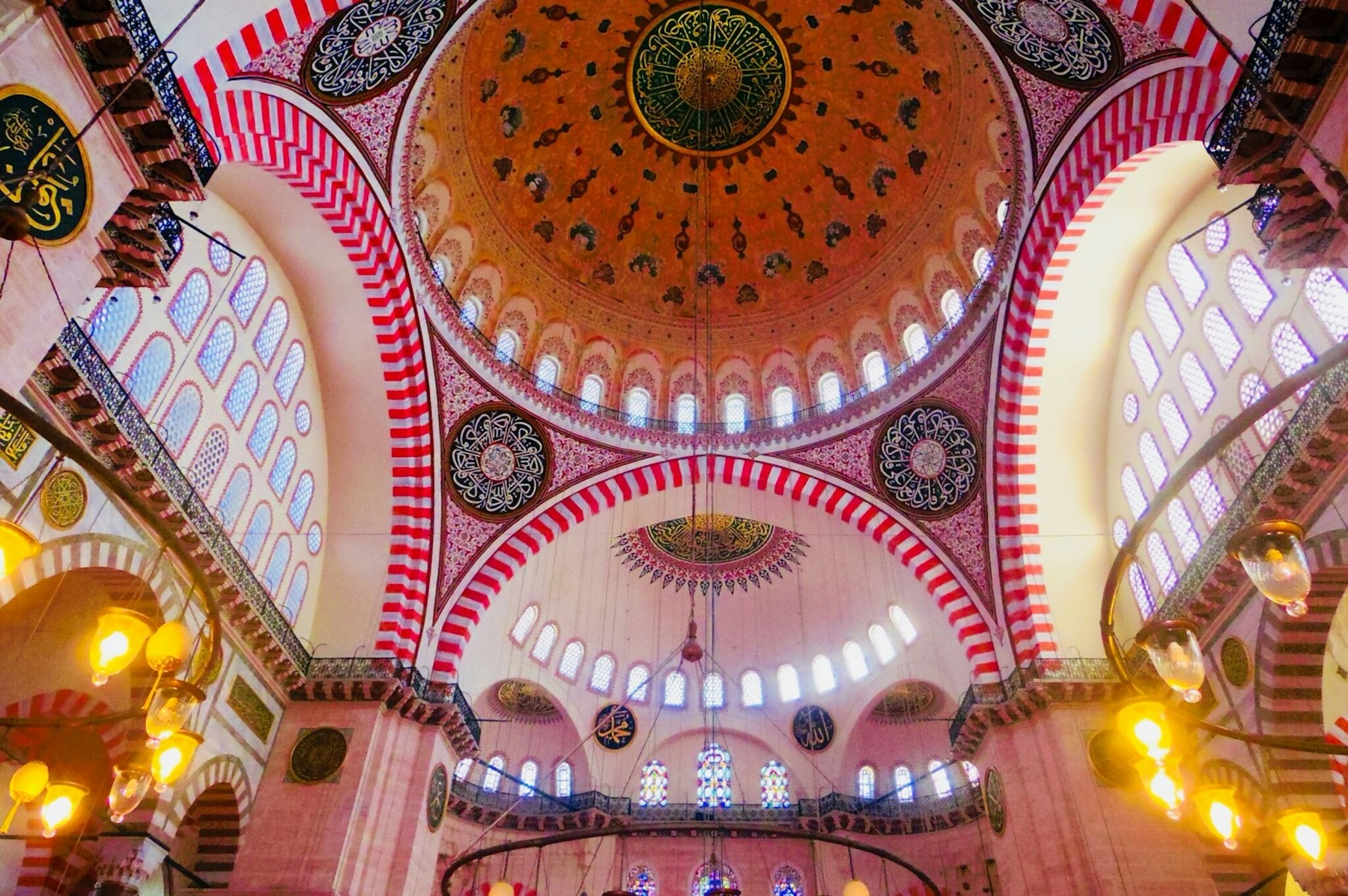 Interior of a mosque featuring a grand dome and decorative arches