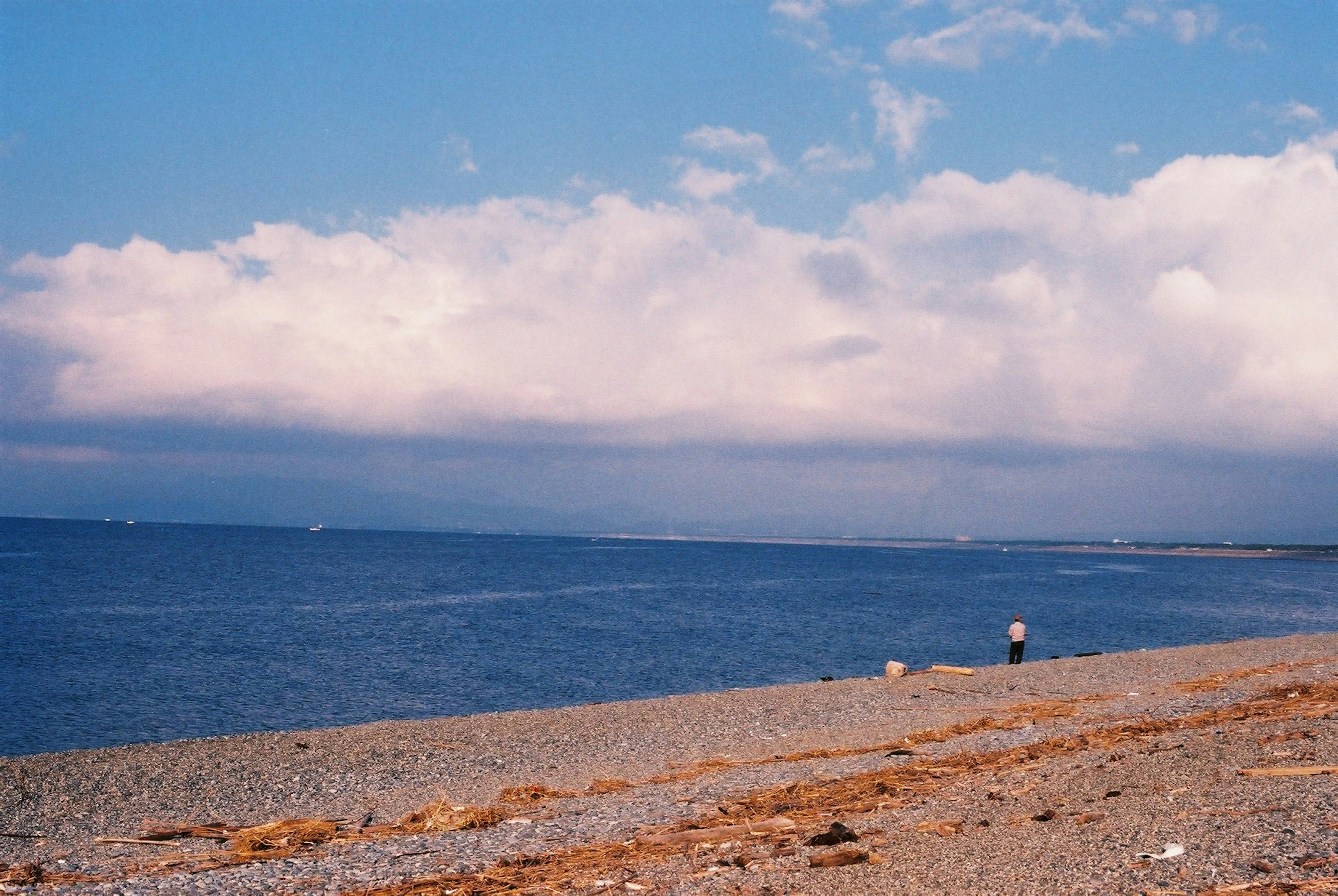 Strandszene mit blauem Meer und bewölktem Himmel