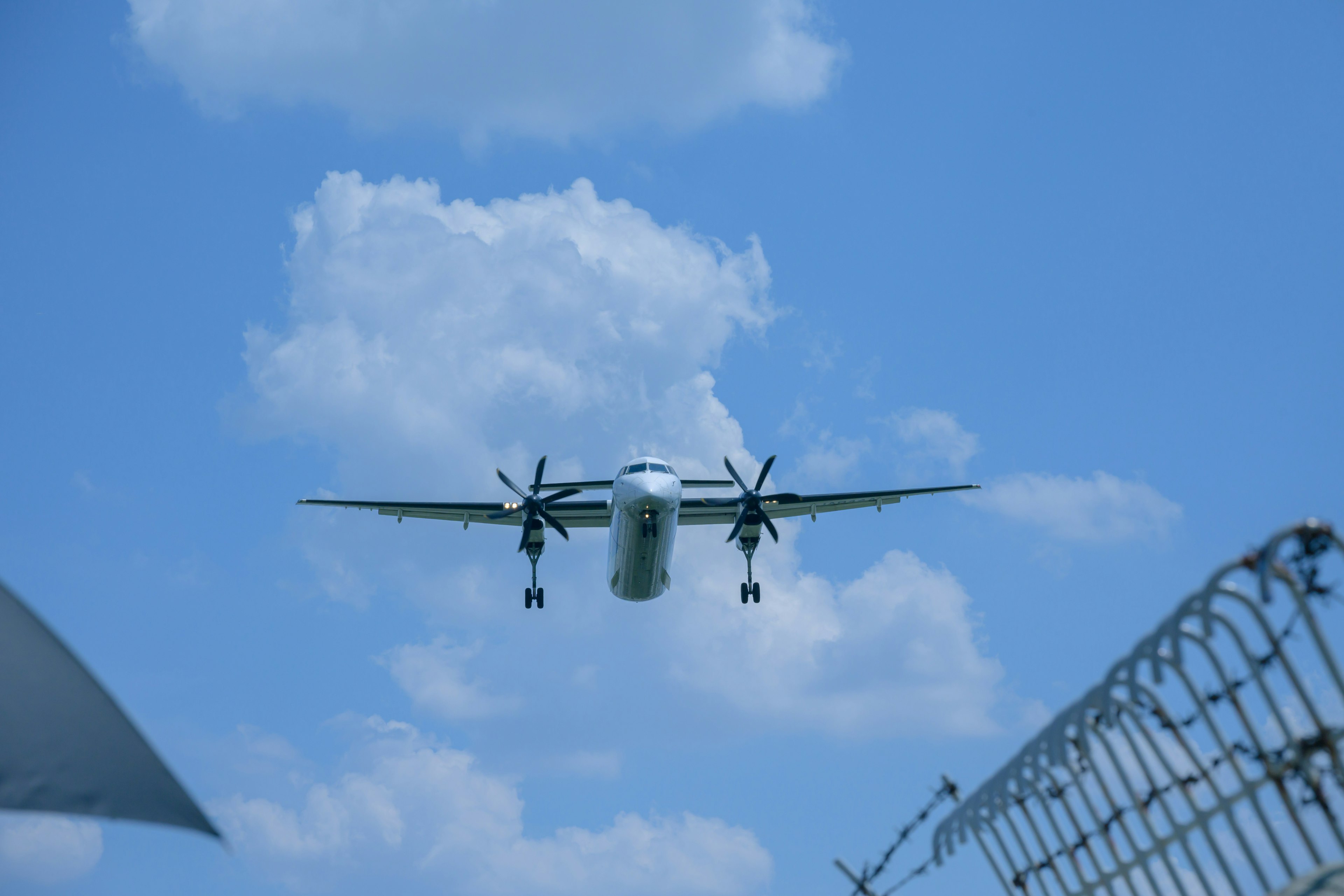 Propellerflugzeug fliegt im blauen Himmel mit Wolken