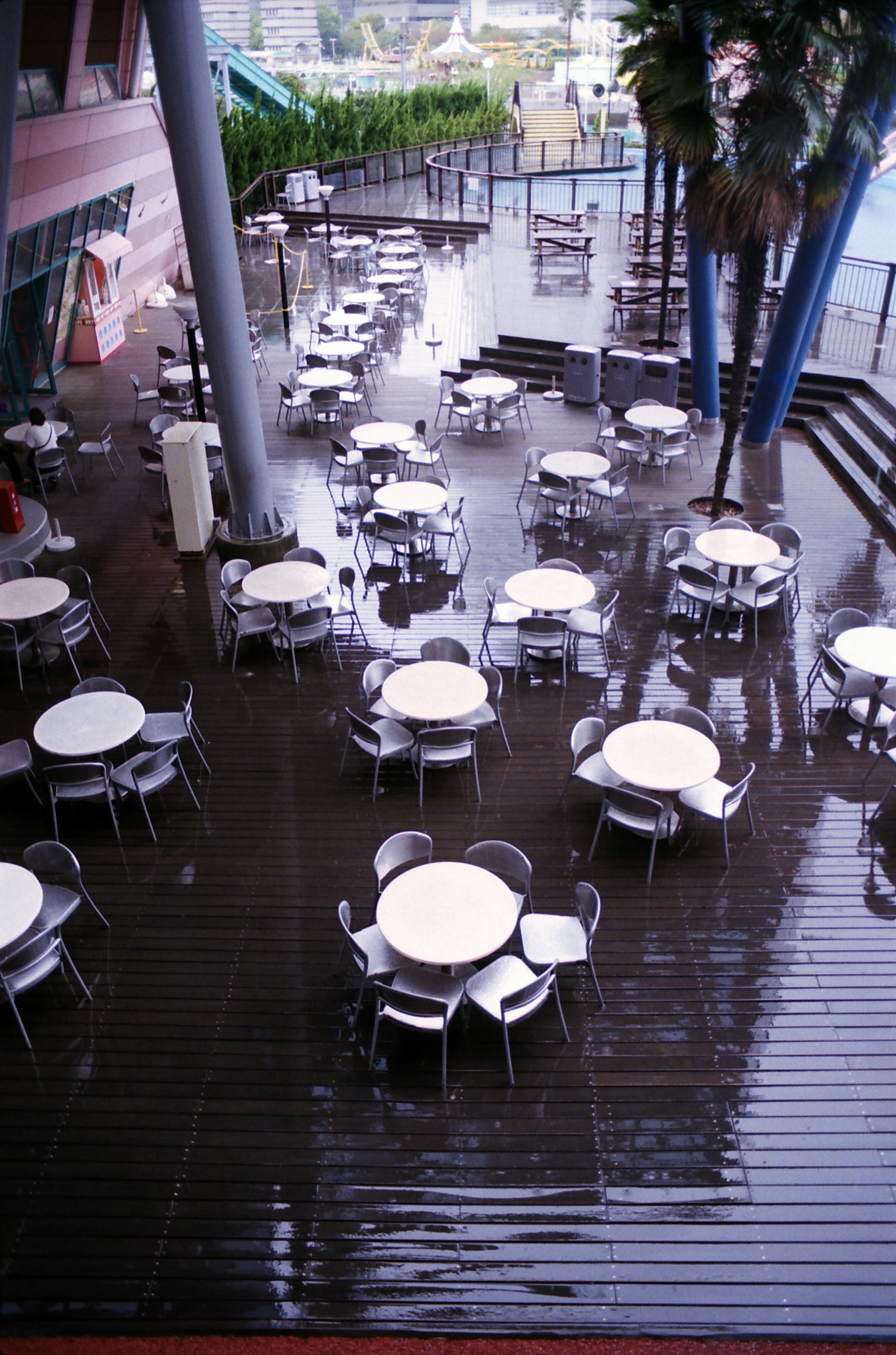 Terraza empapada por la lluvia con mesas y sillas dispuestas