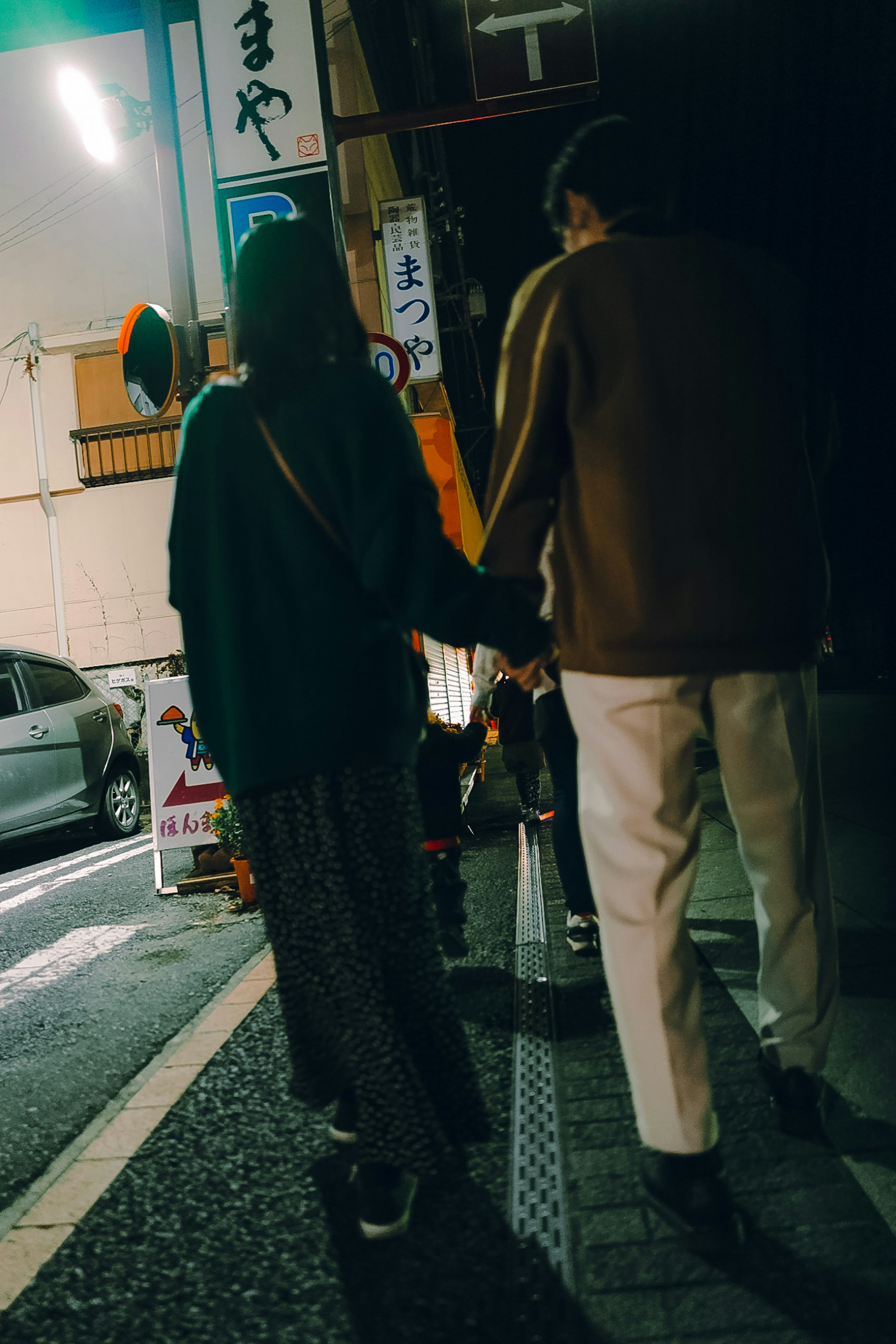 Couple walking hand in hand on a night street