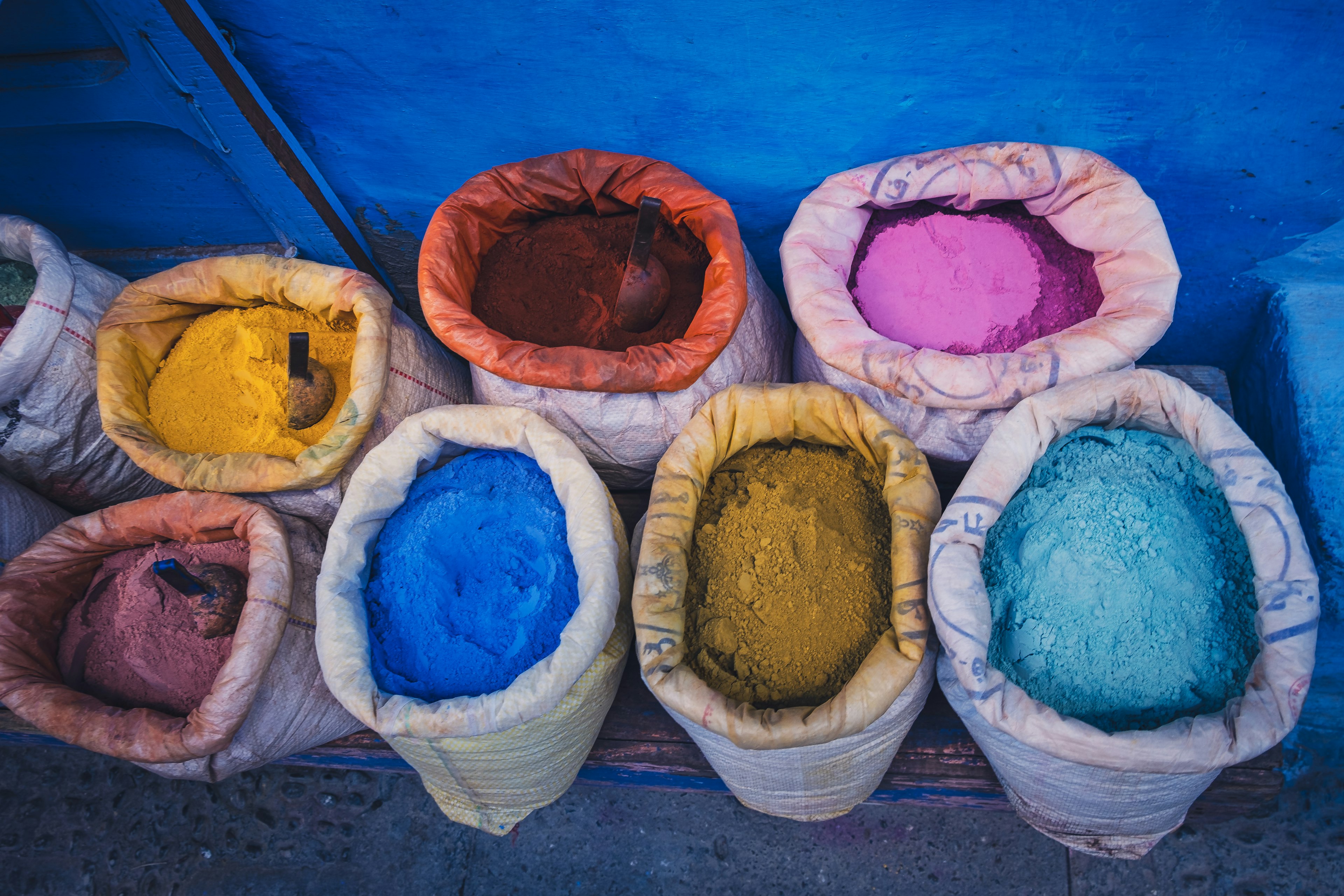 Bolsas coloridas de polvo dispuestas sobre un fondo azul