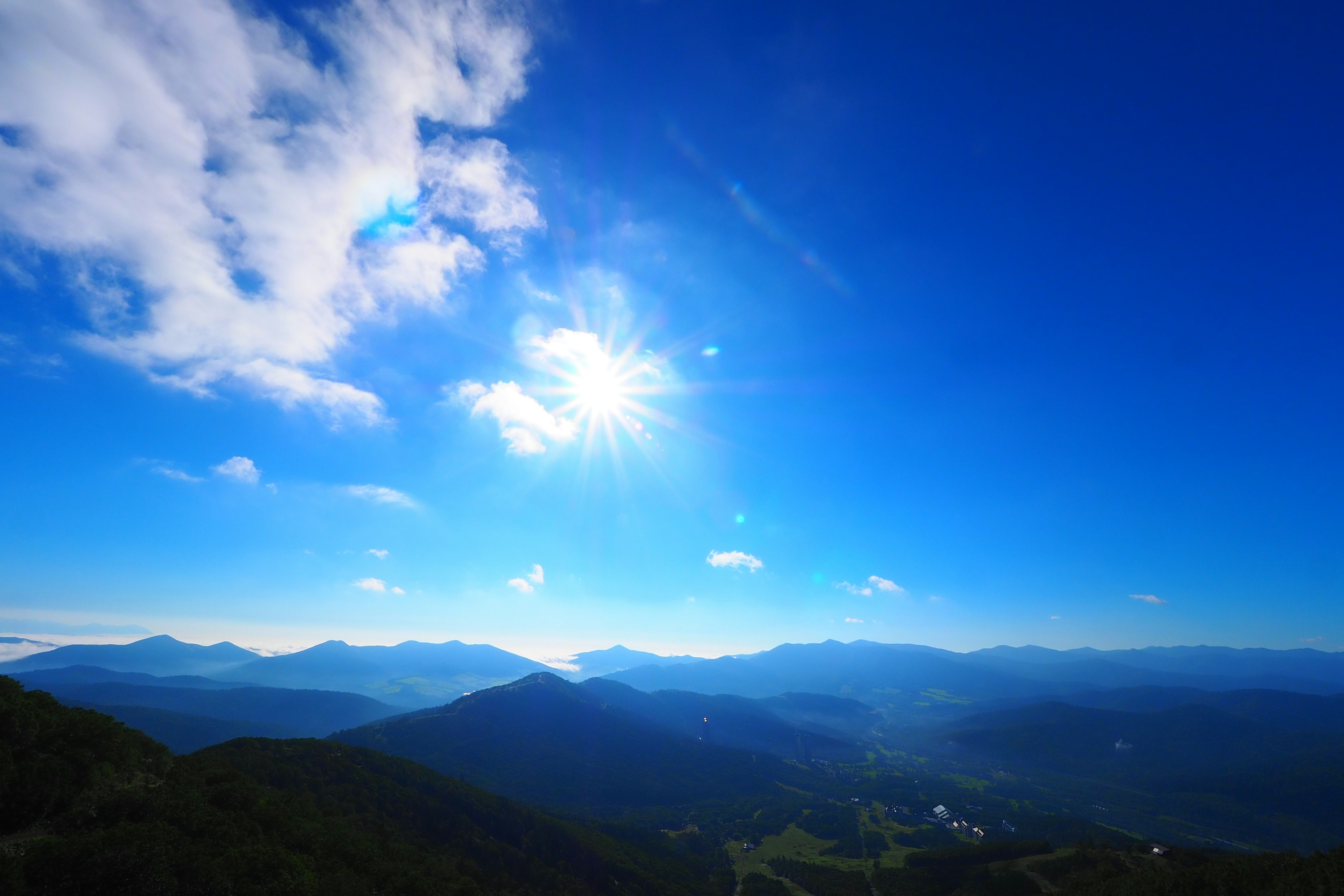 맑은 파란 하늘과 태양 아래의 산 경치