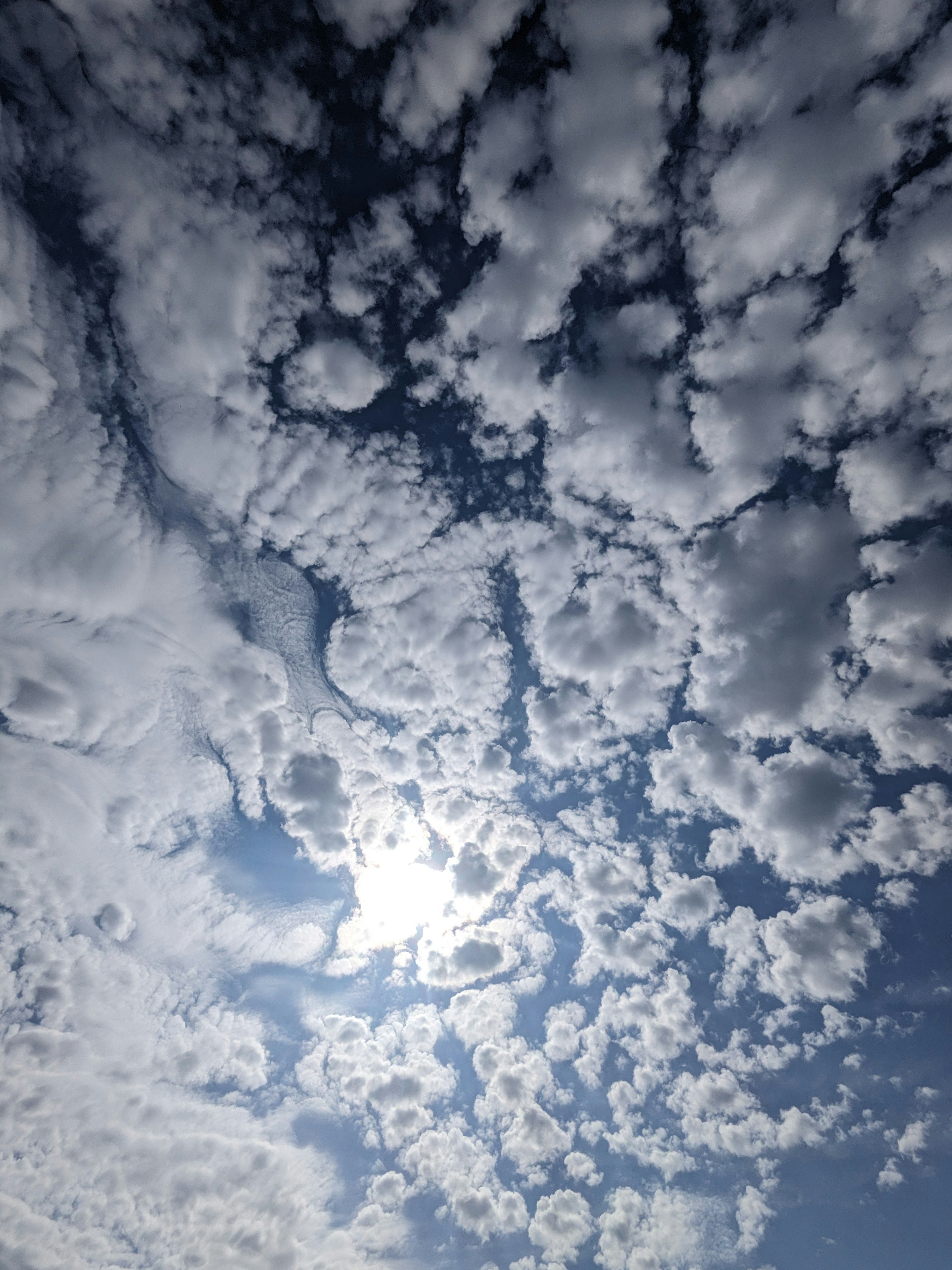 青空に白い雲が広がり太陽の光が差し込む