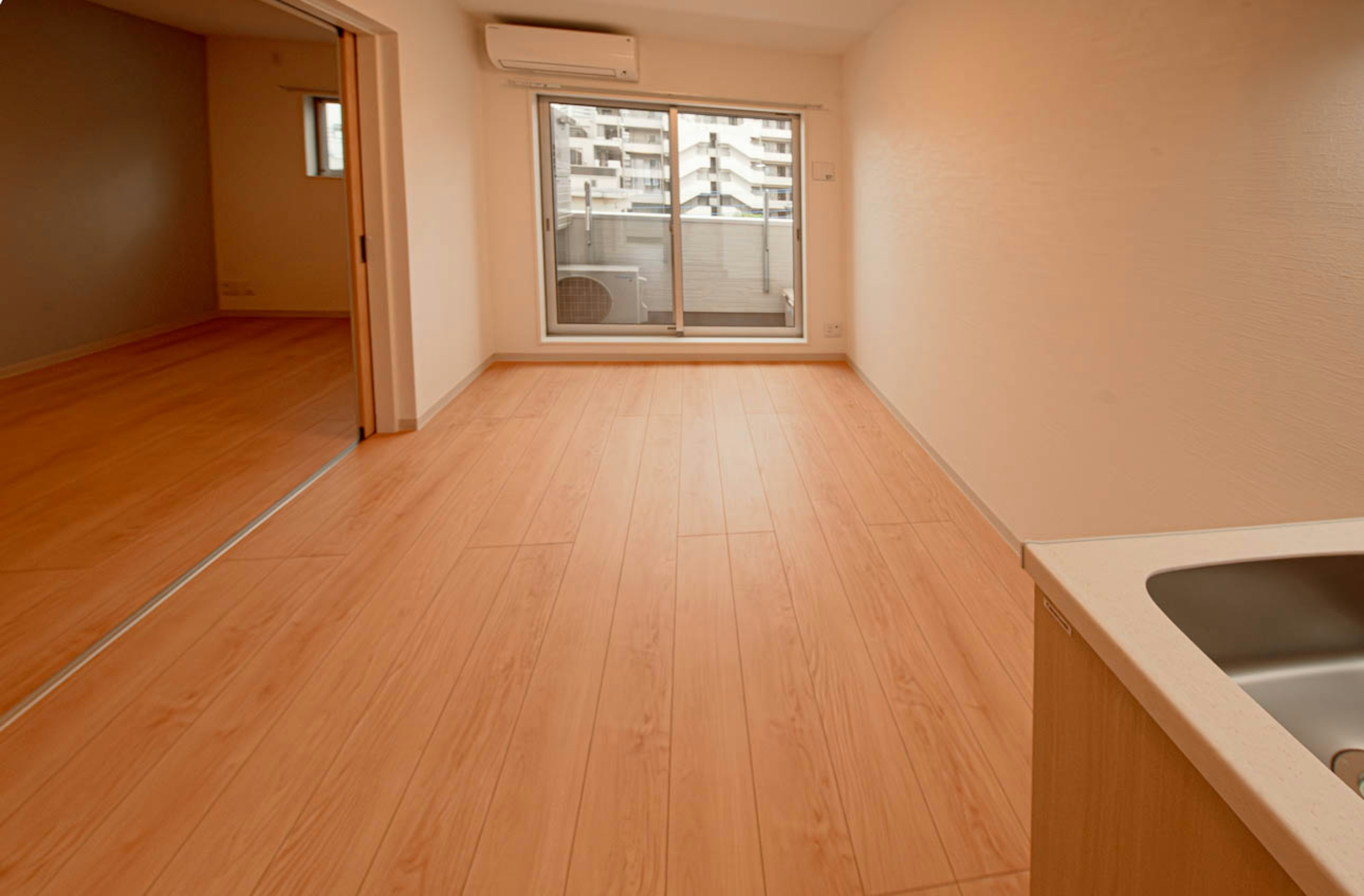 spacious living area with balcony and wooden flooring