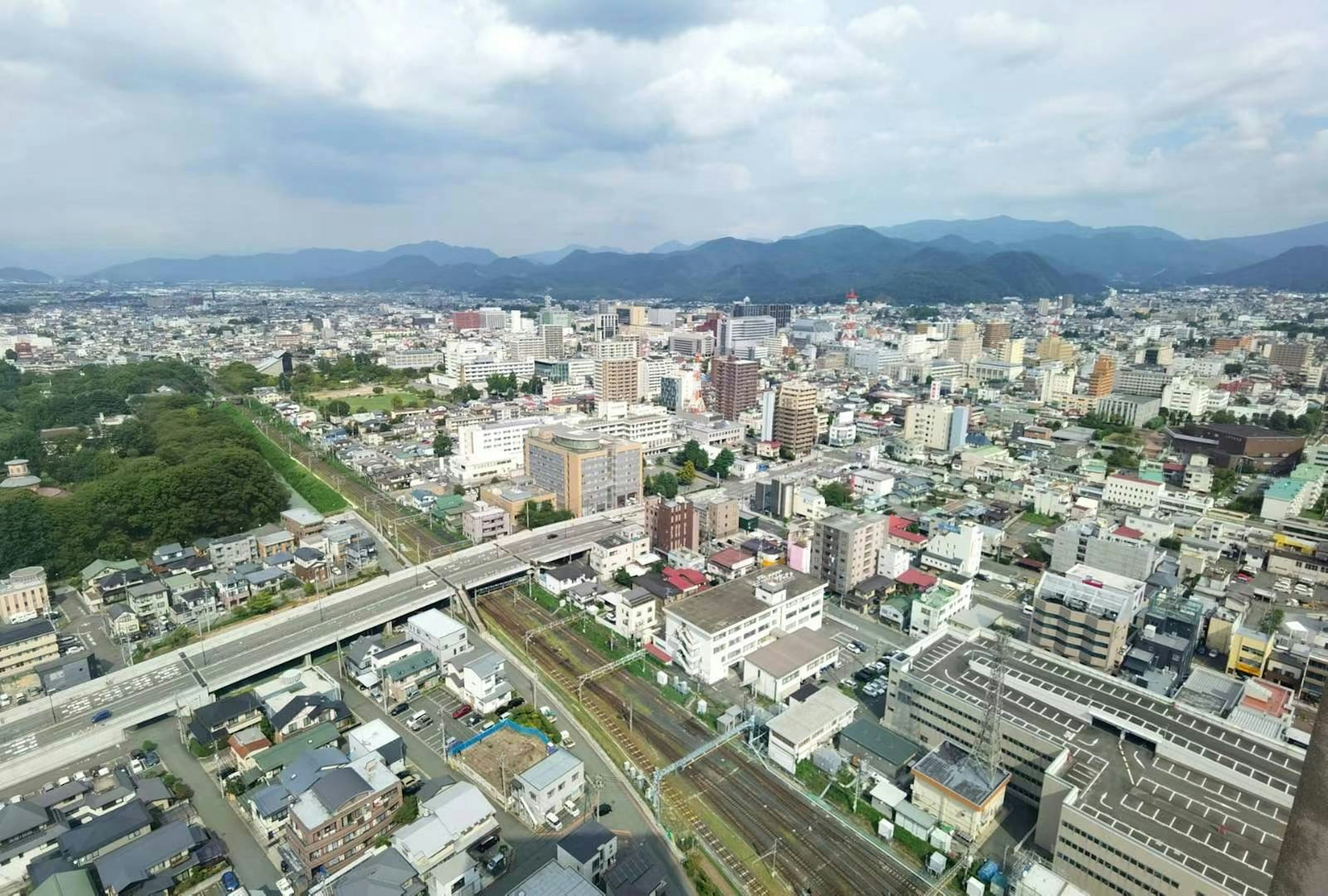 Vista aérea de una ciudad japonesa con edificios y montañas al fondo