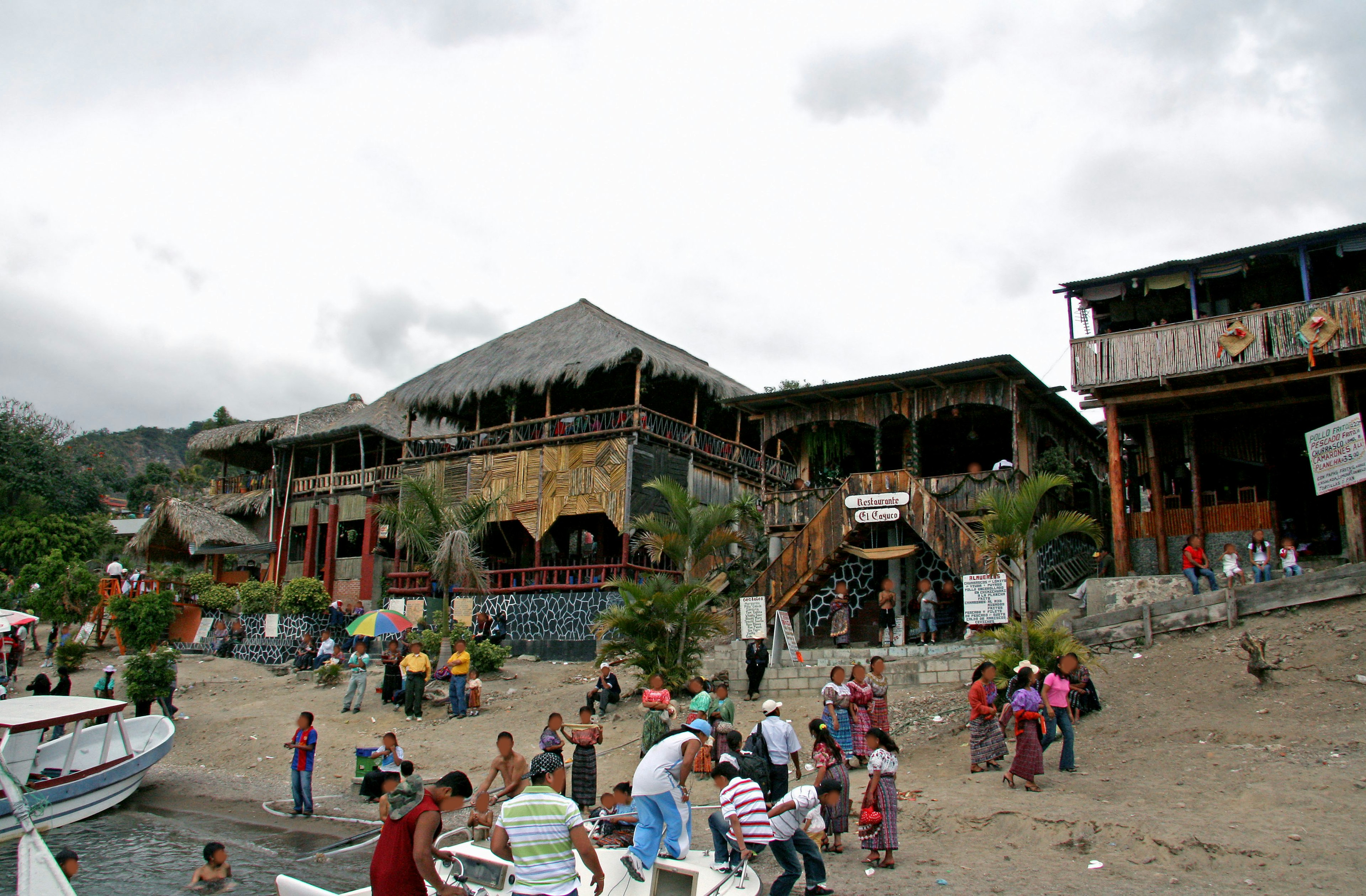 Eine belebte Strand-Szene mit einem Restaurant und vielen versammelten Menschen