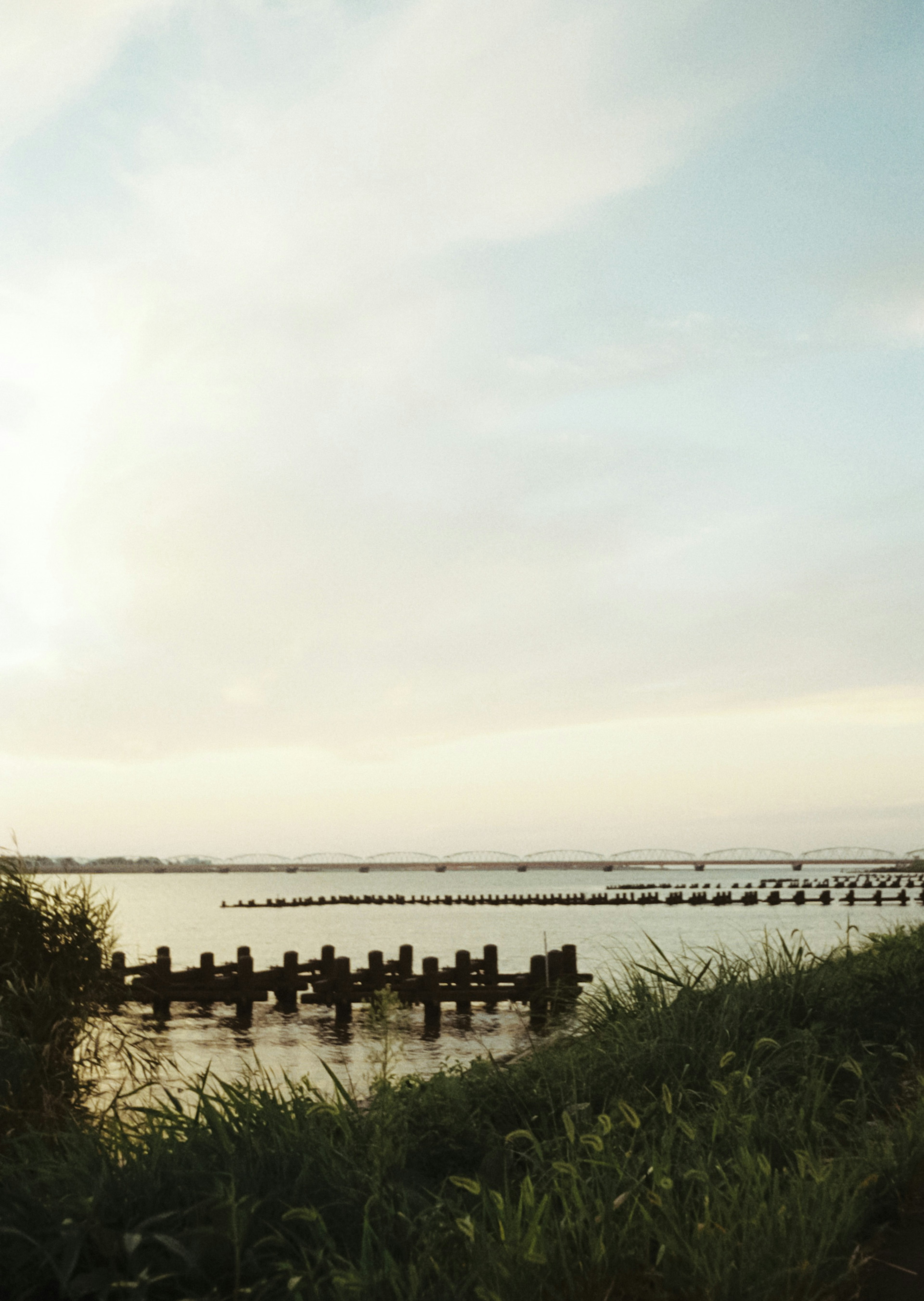 Muelle de madera junto a un lago tranquilo con un cielo sereno