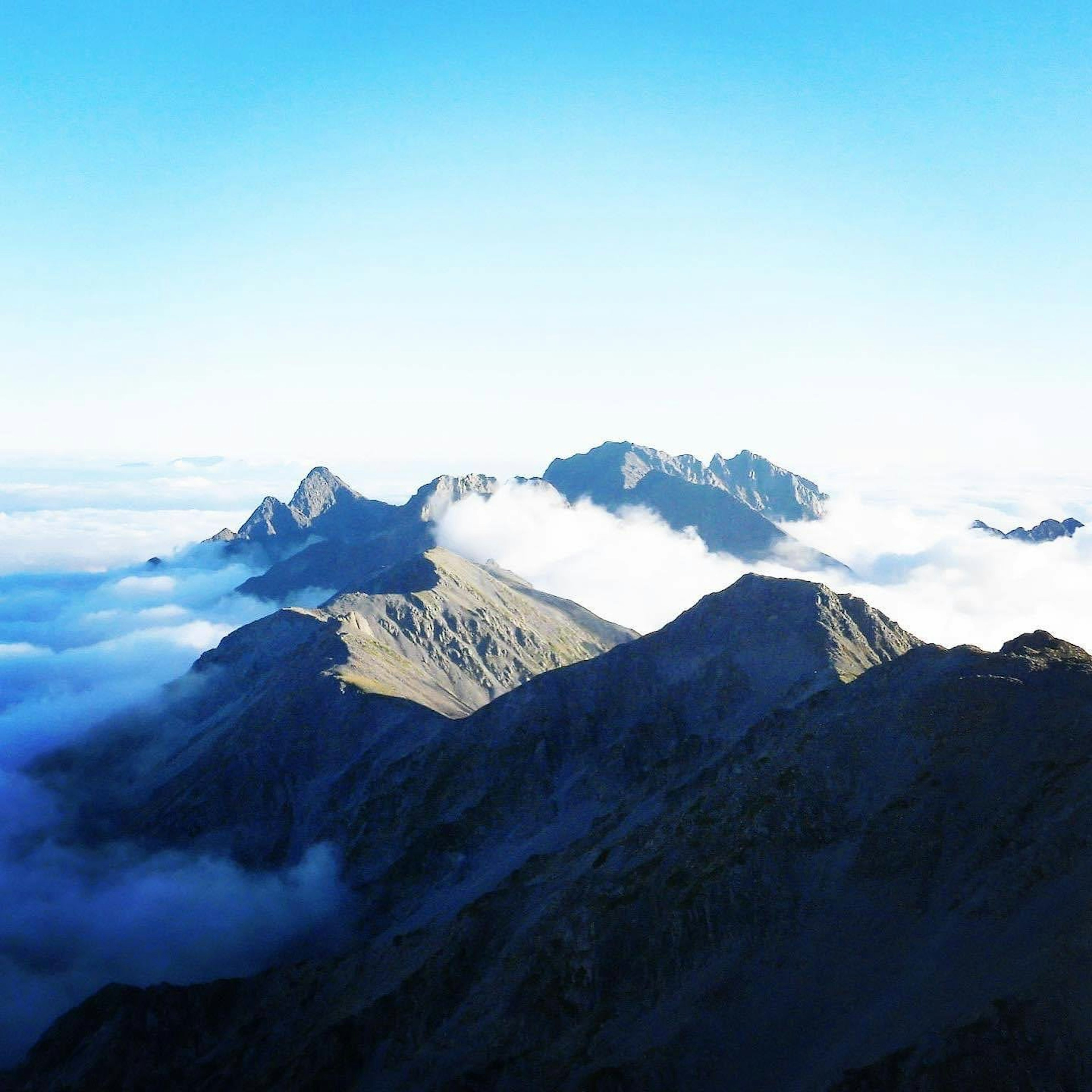 青空の下に広がる山々と雲の景色