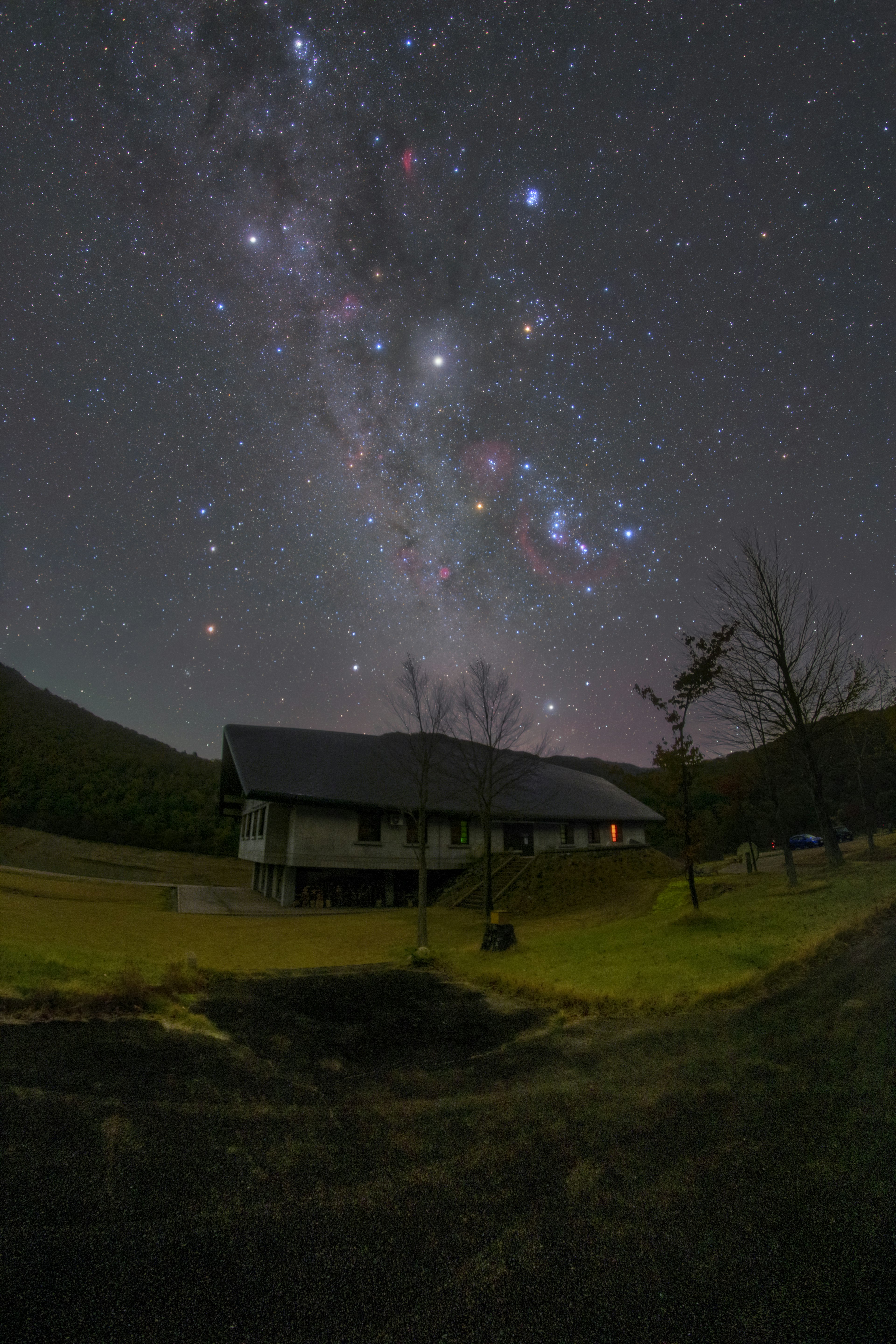 星空の下にある家と周囲の風景