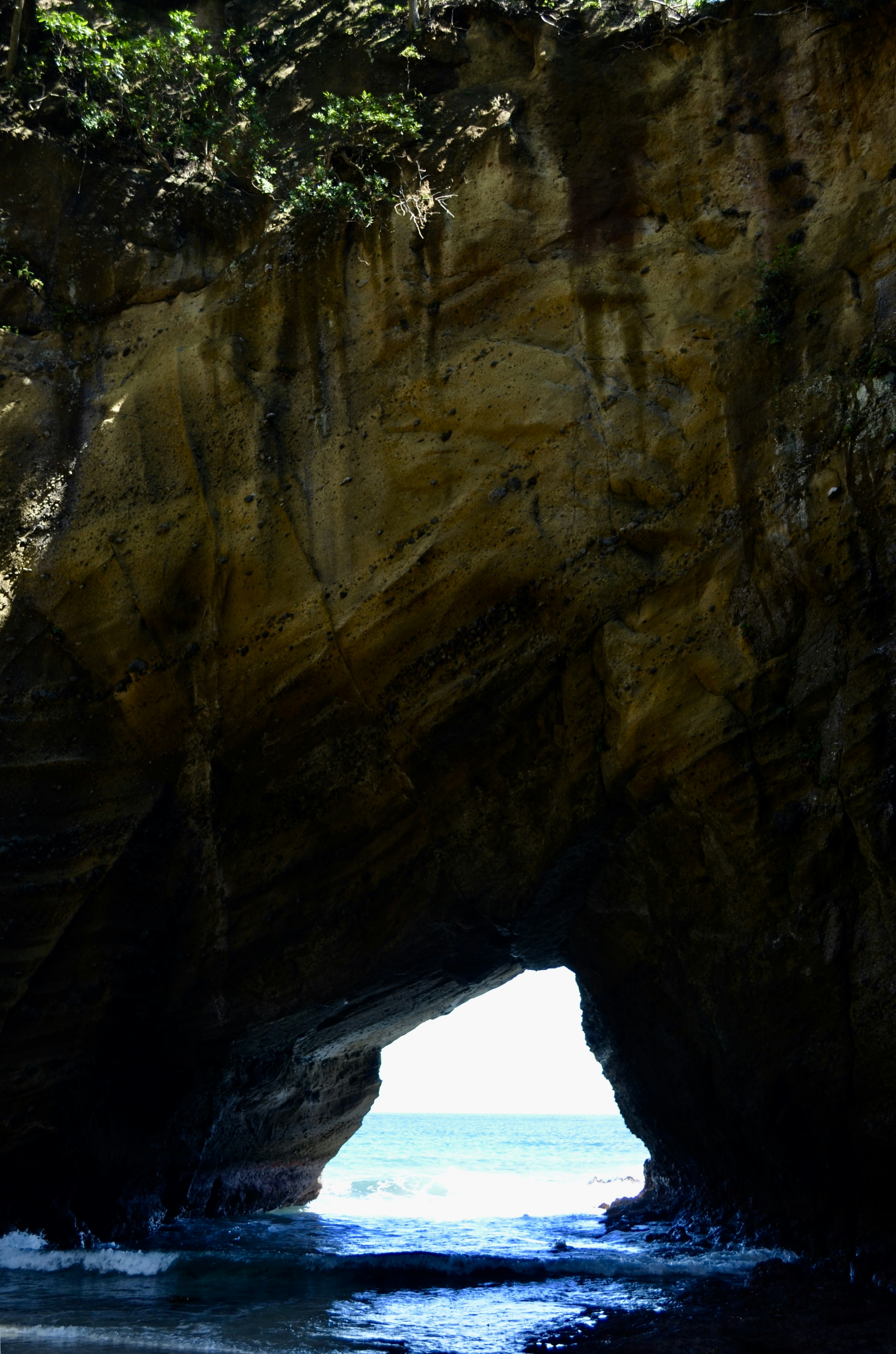 Entrada de la cueva que revela un océano azul y paredes rocosas