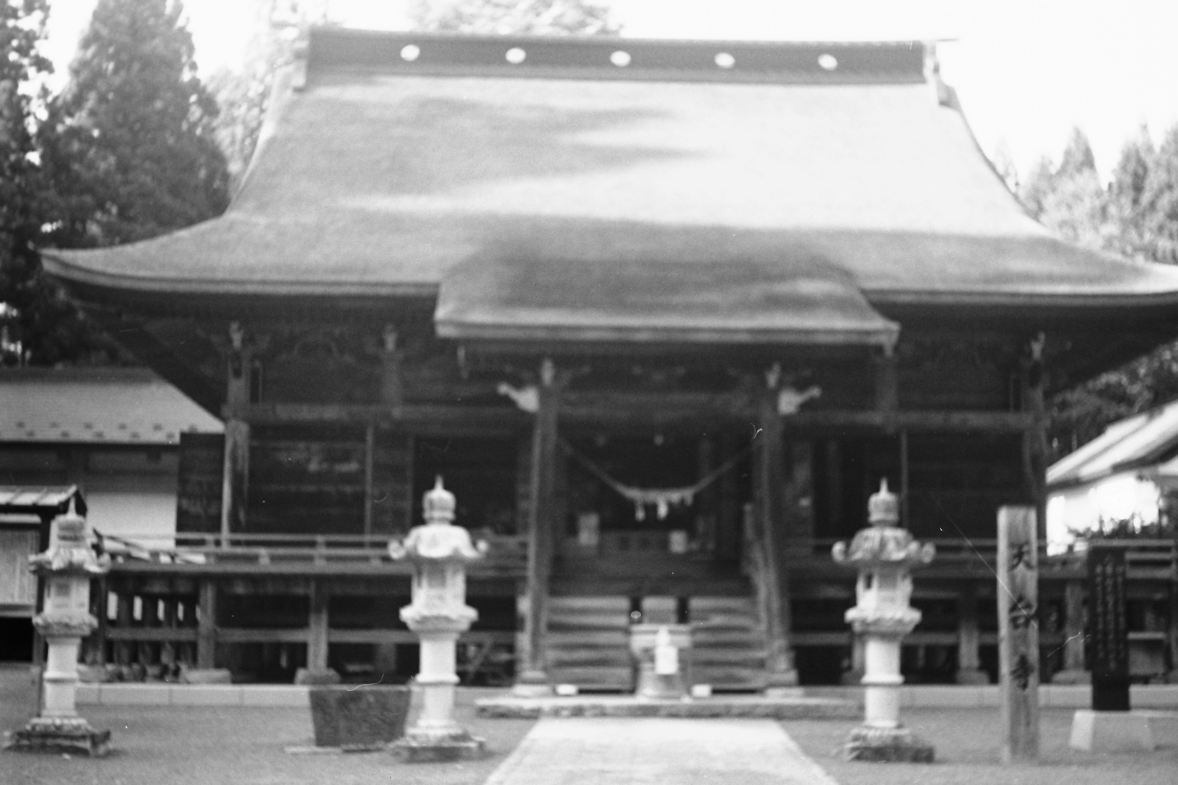 Traditional shrine architecture with stone lanterns in a serene setting