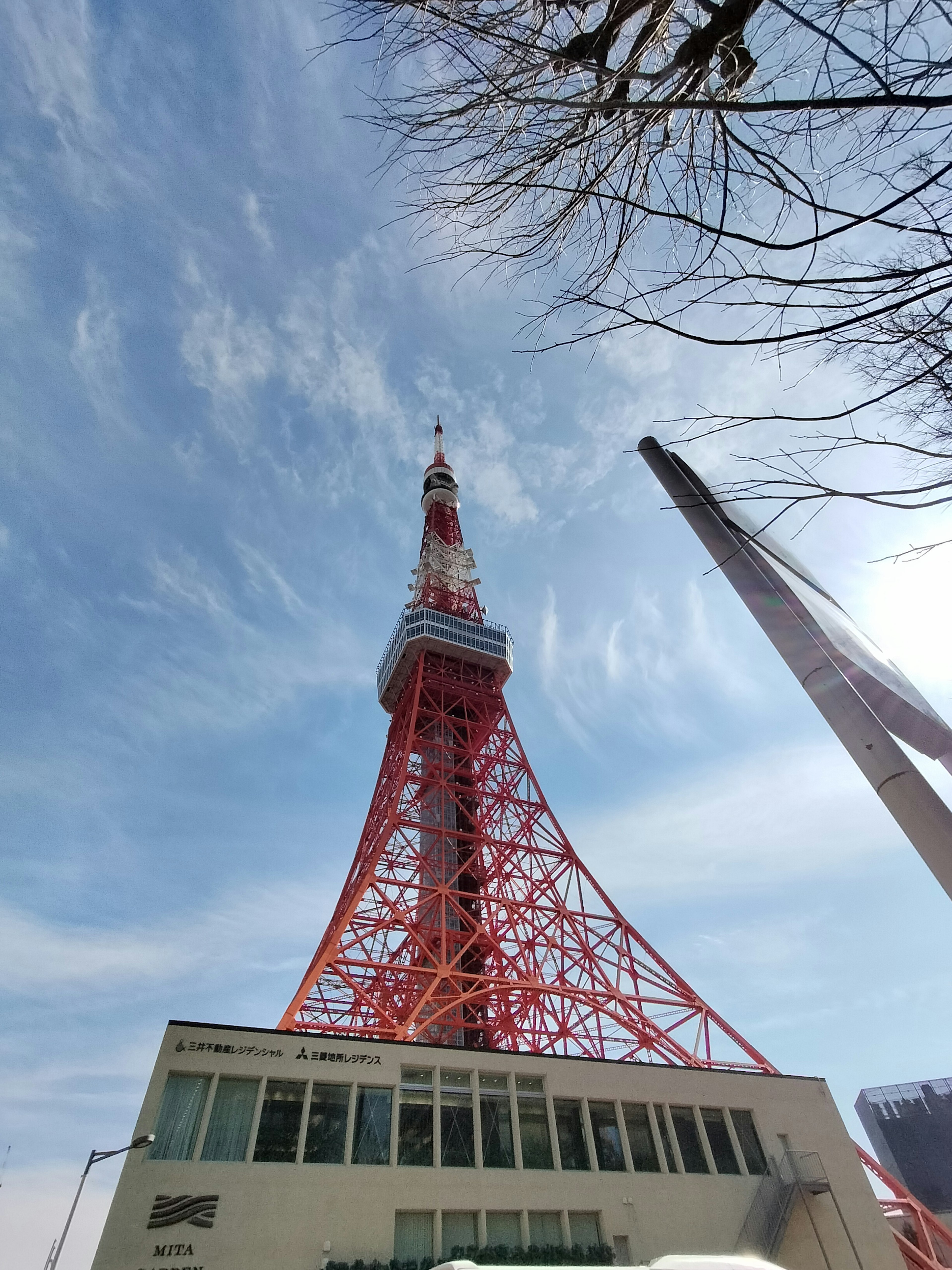 Die rote Struktur des Tokyo Towers steht vor einem blauen Himmel