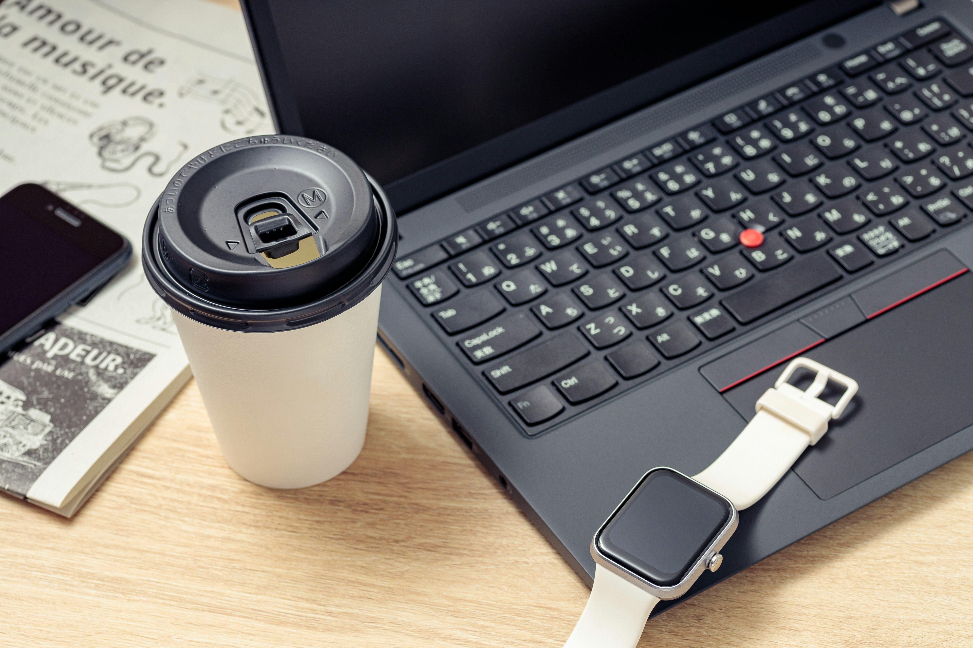 Escena de escritorio con laptop taza de café smartphone y smartwatch