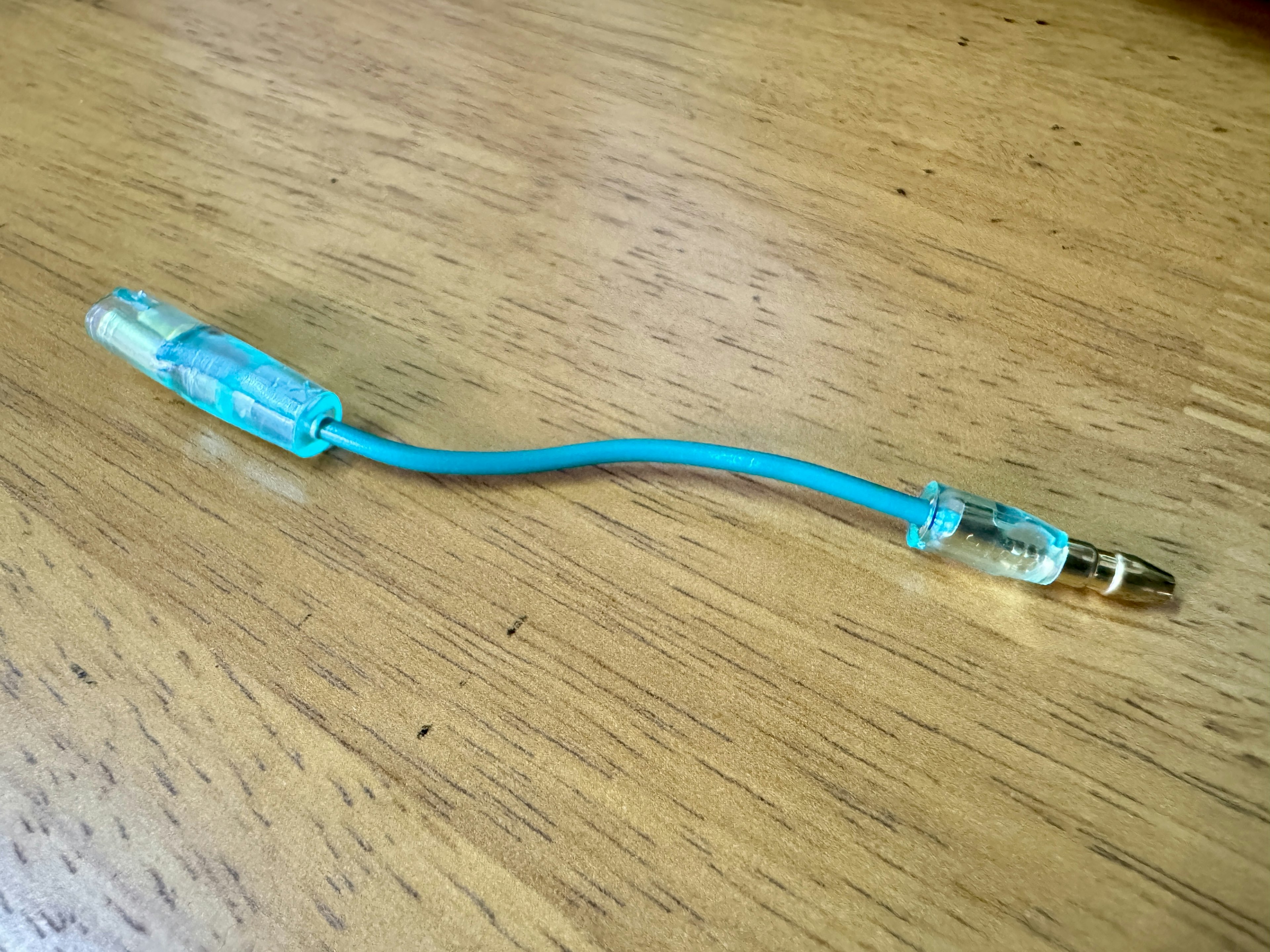 Conector de cable azul sobre una mesa de madera