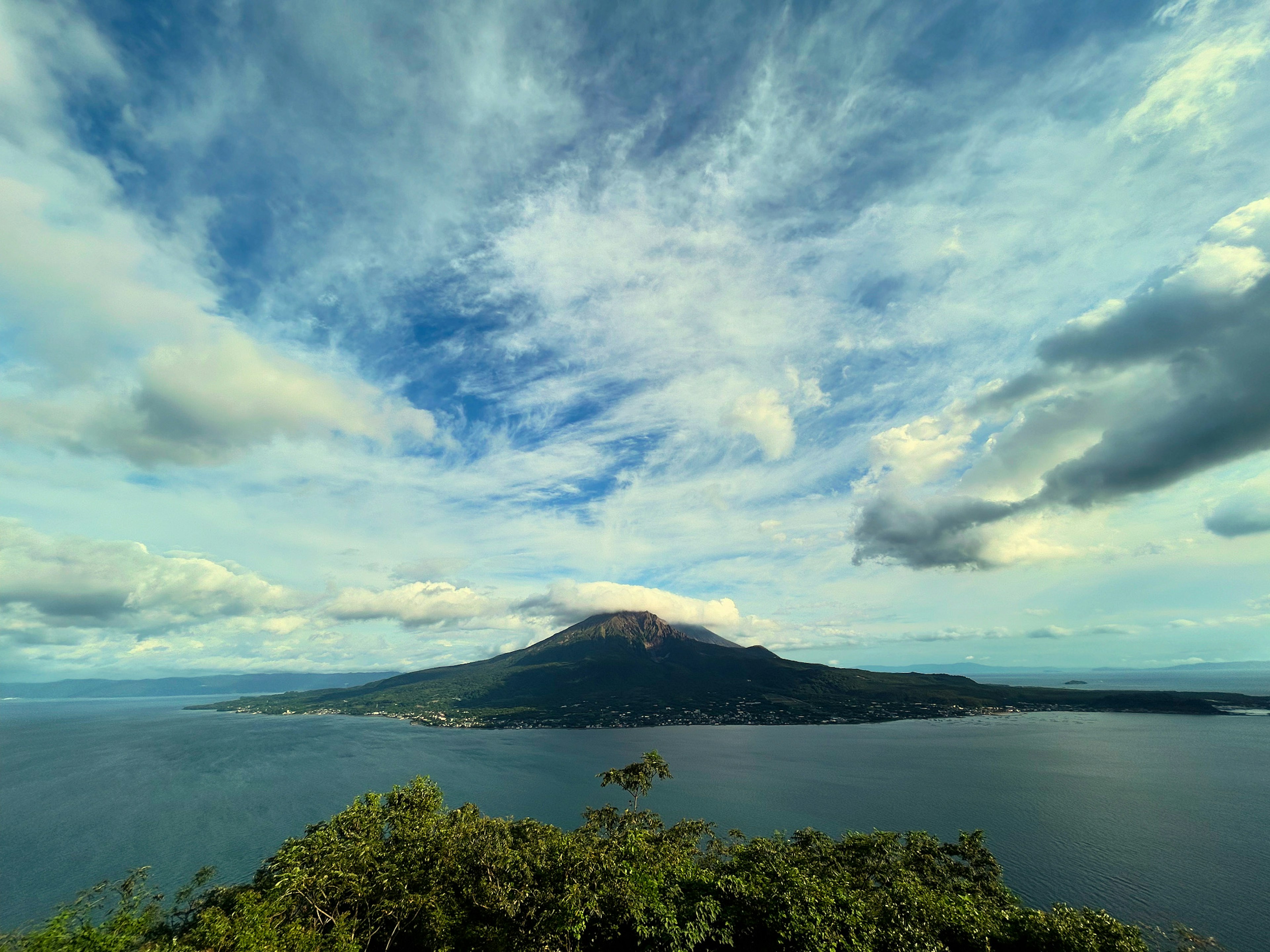 Vista escénica de una isla rodeada de nubes y cielo azul