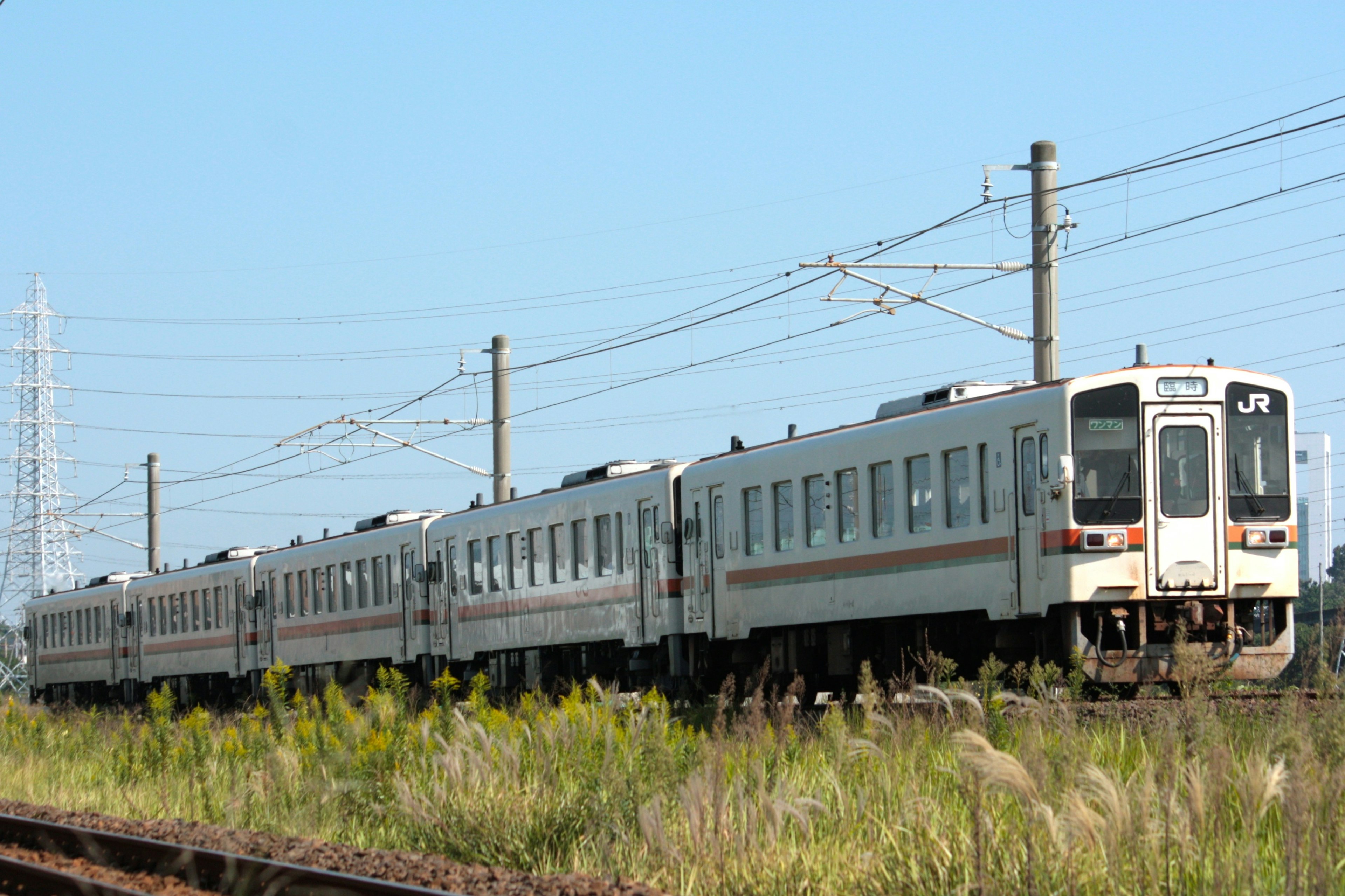 A white train moving under a blue sky