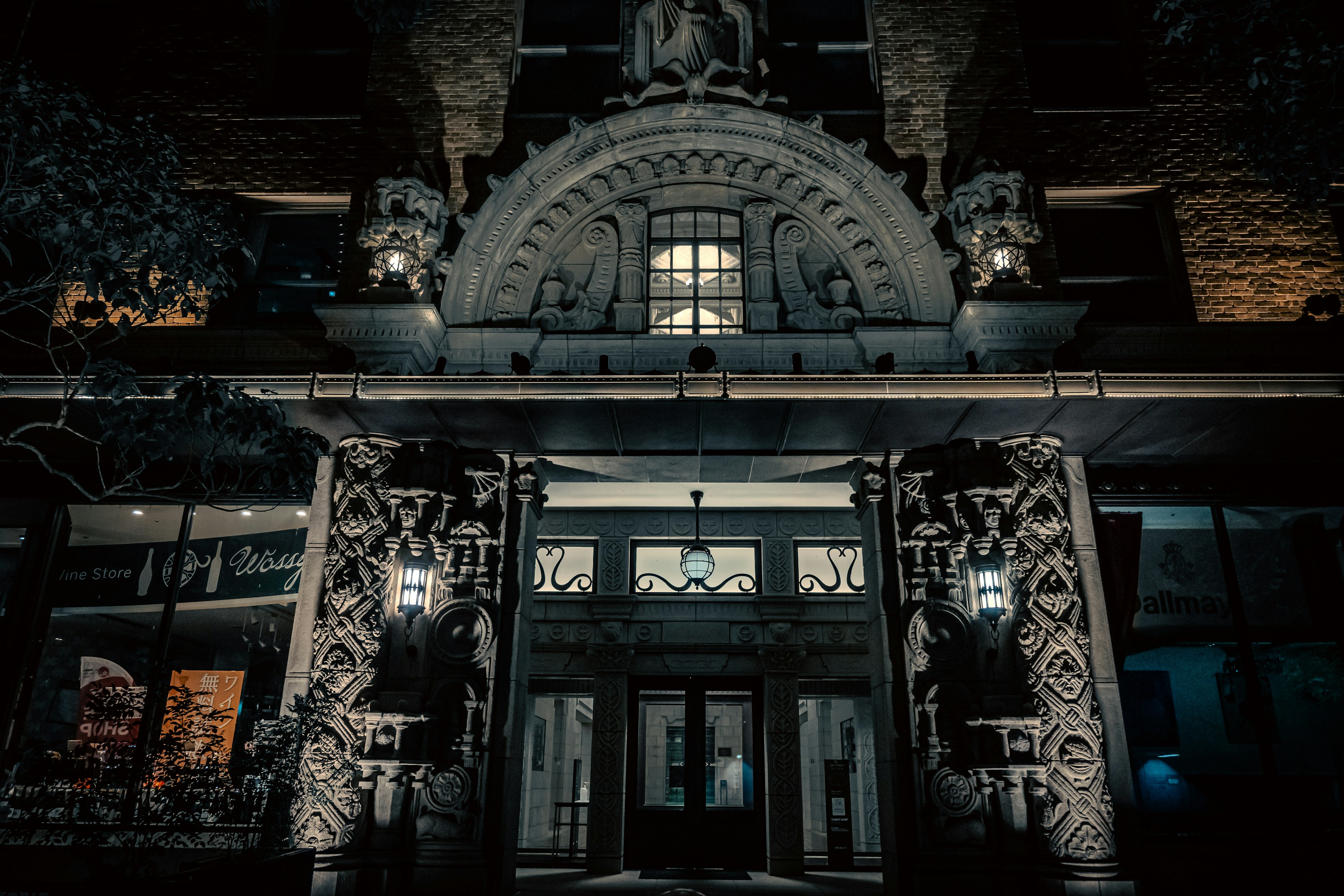 Entrance of a building at night featuring intricate sculptures and lighting