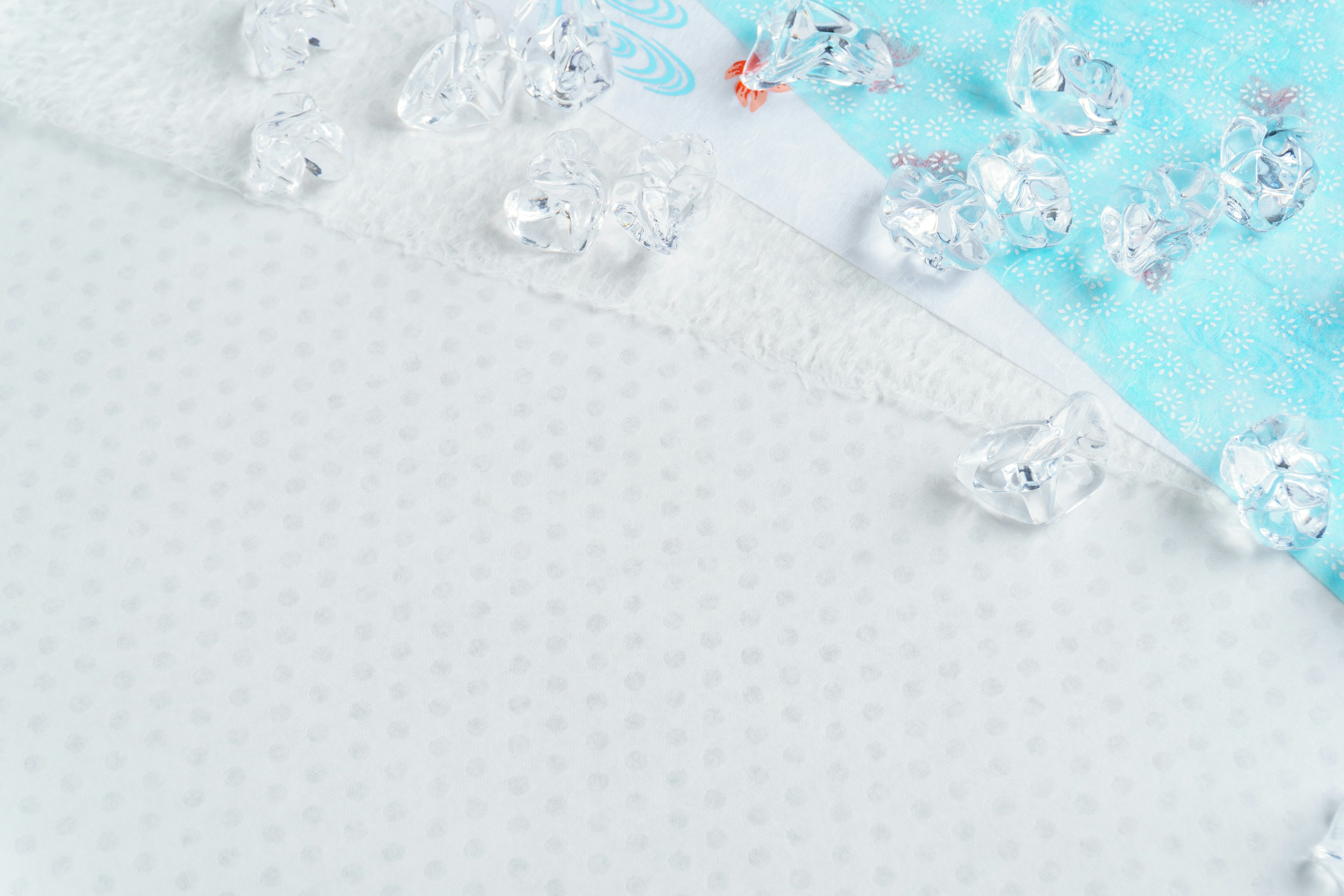 White fabric with polka dots and scattered crystal decorations on a blue background