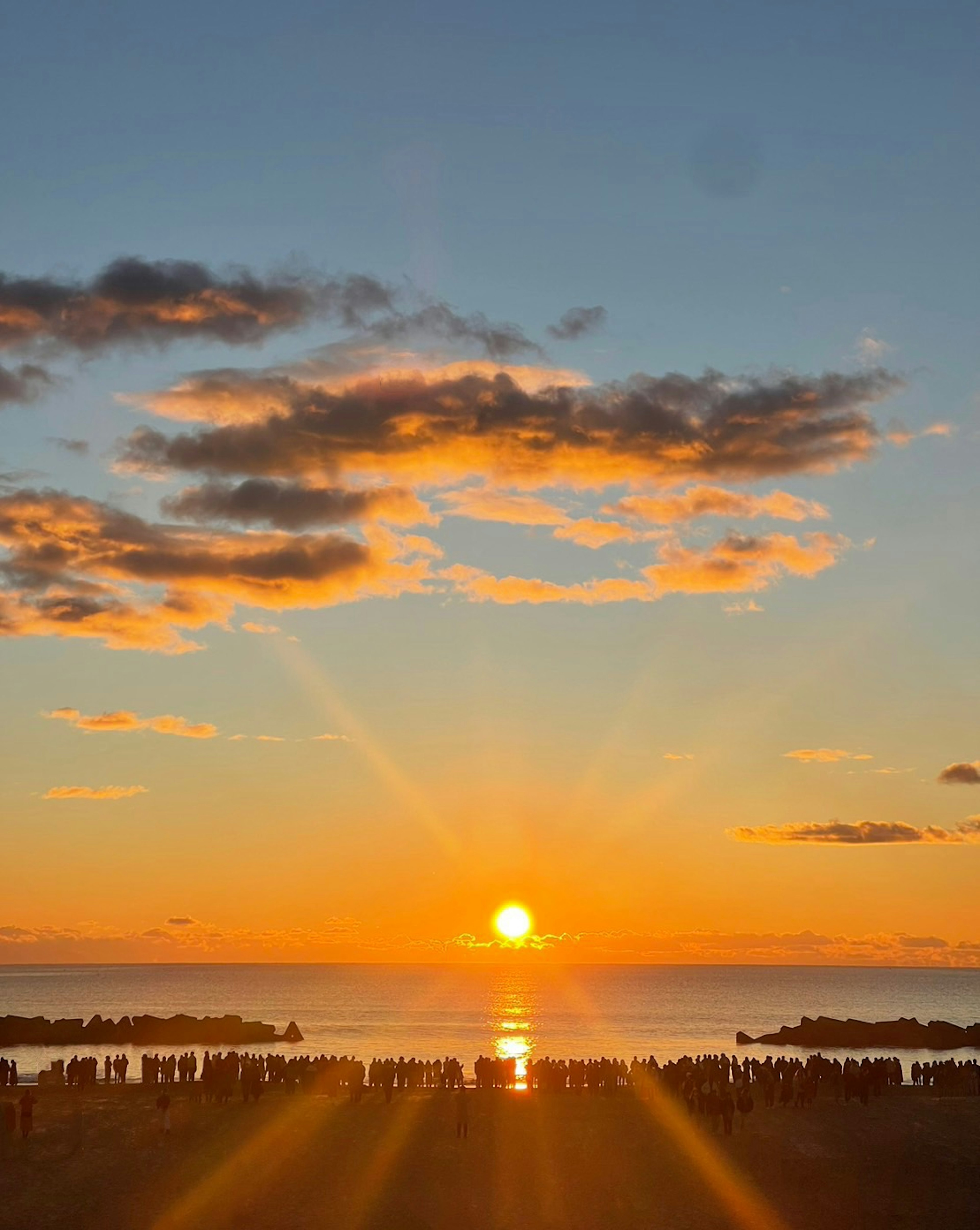 美しい夕日が海に沈む光景と雲のある空