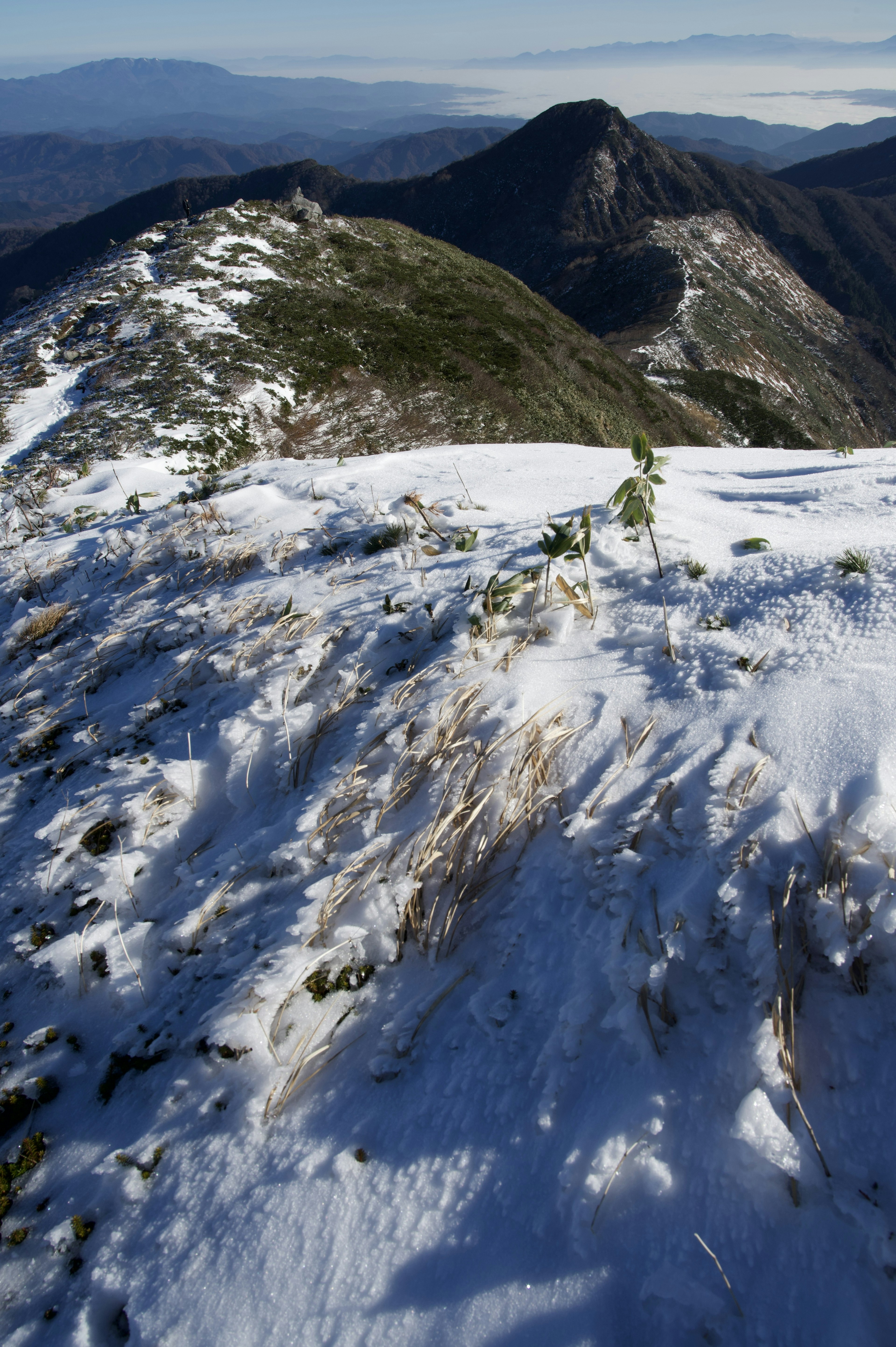 雪に覆われた山頂と背景の山々の風景