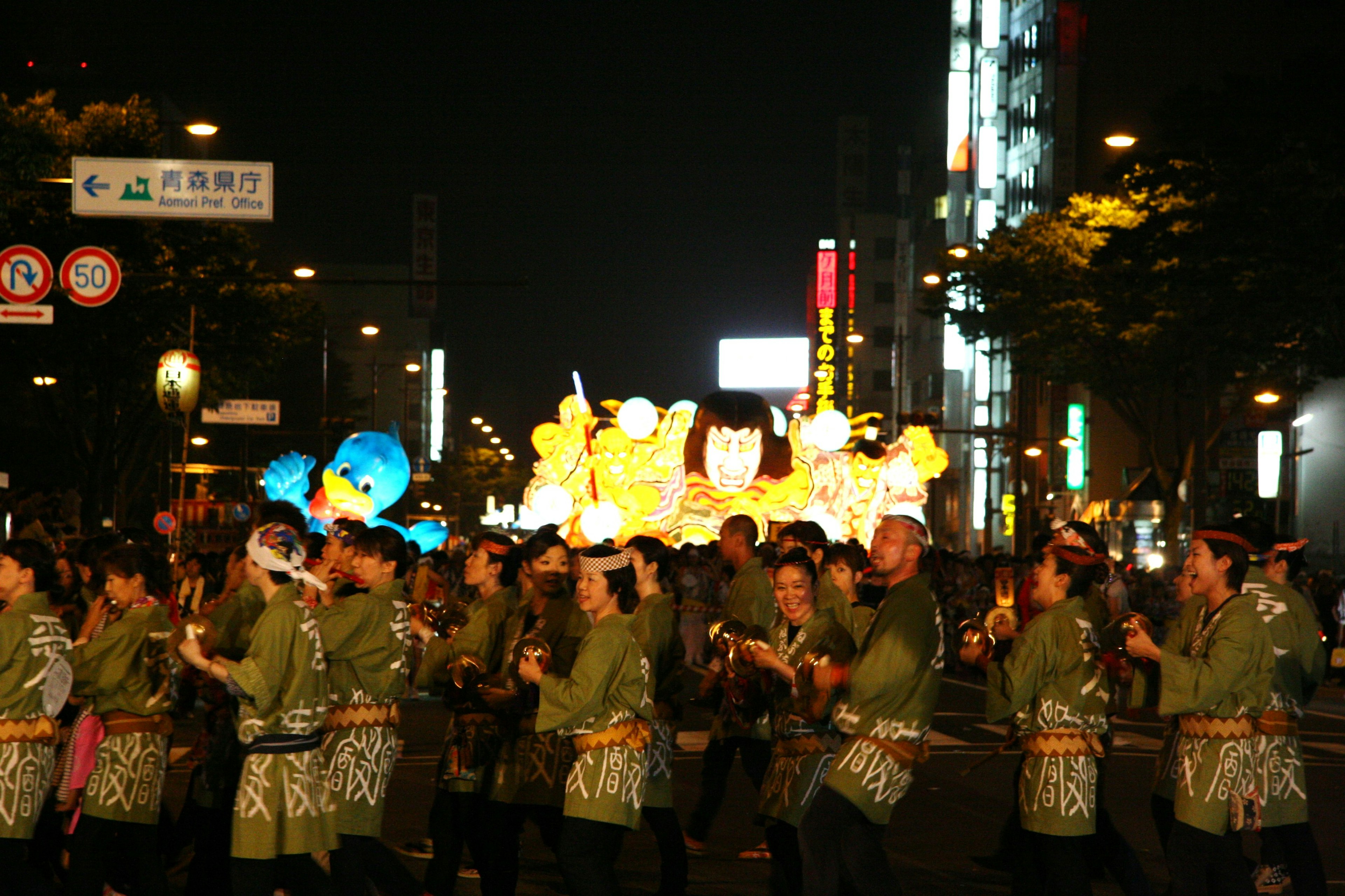 Personas bailando en un festival nocturno con linternas coloridas