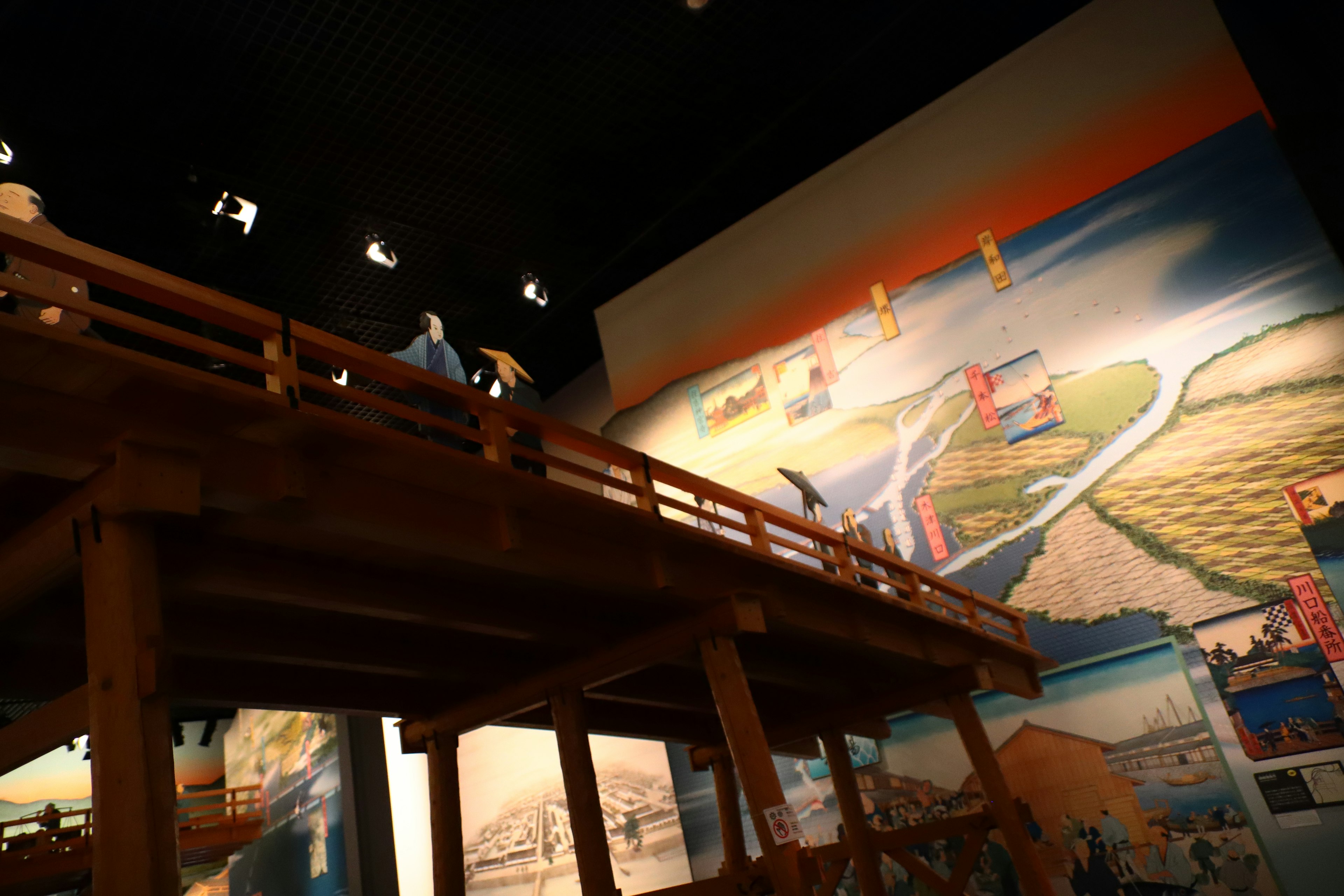 Interior of an exhibition room with a beautiful mural and a wooden bridge