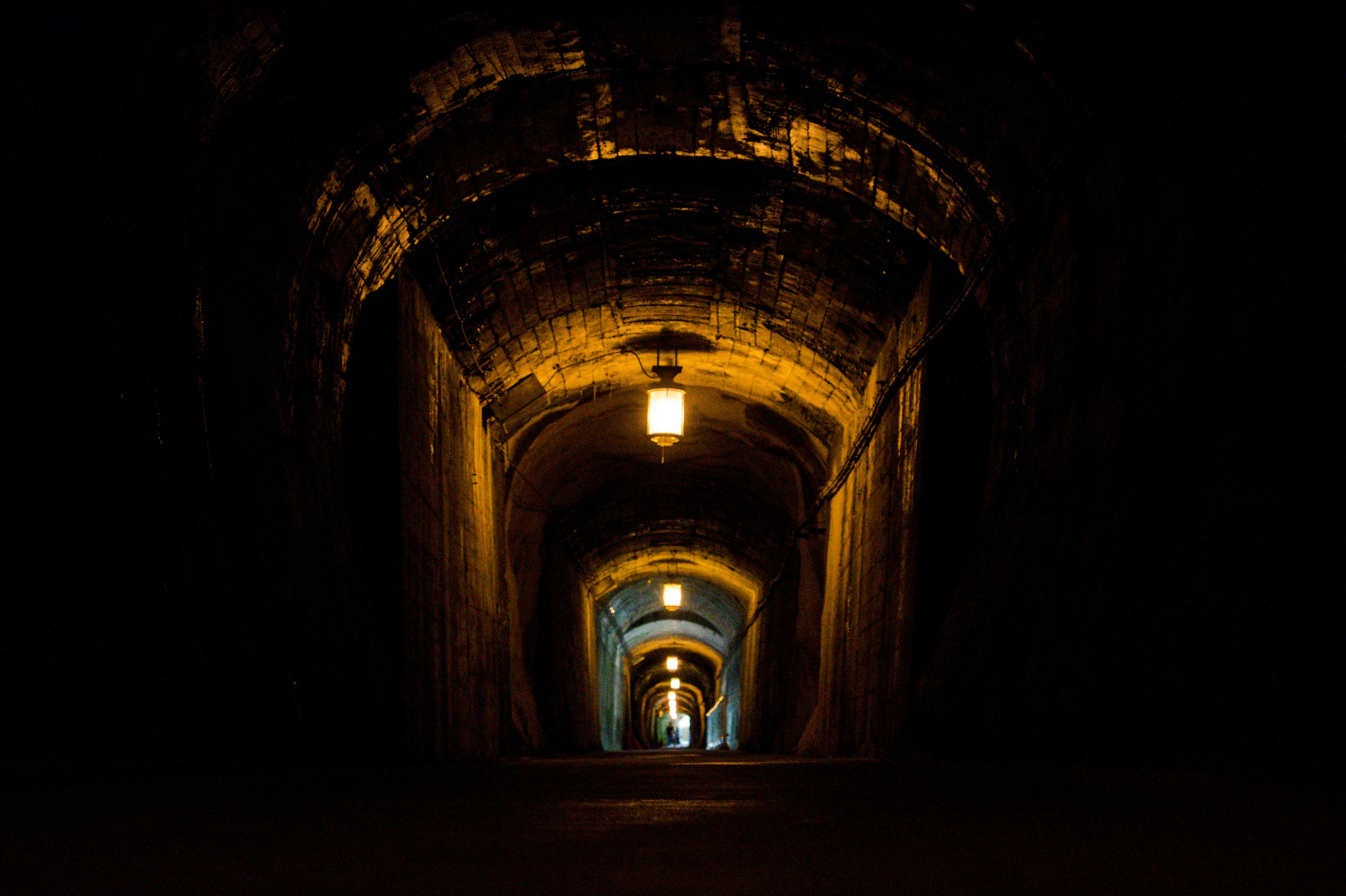 Dark tunnel with warm light illuminating the old archway structure