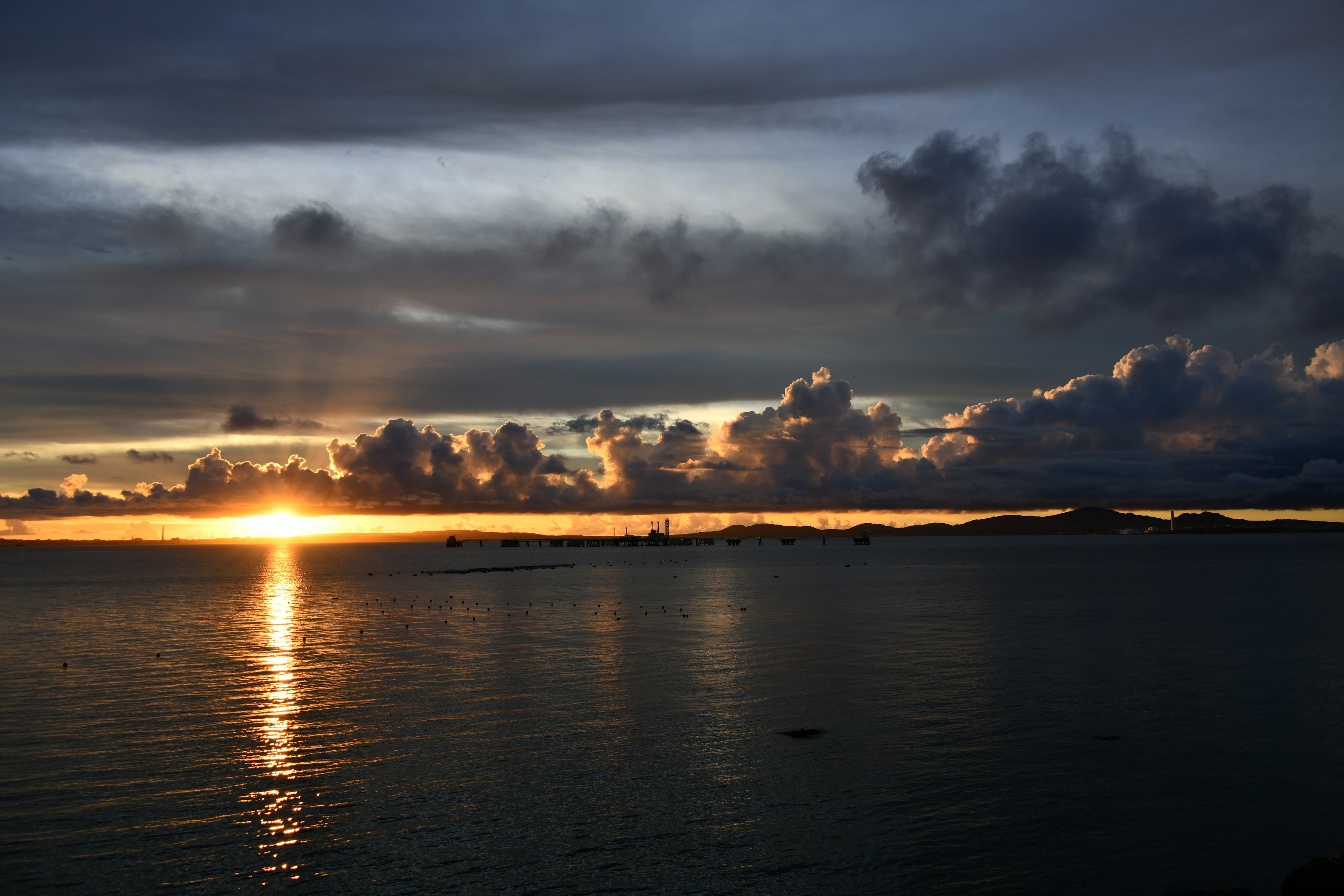 夕日が海に沈む美しい風景と暗い雲