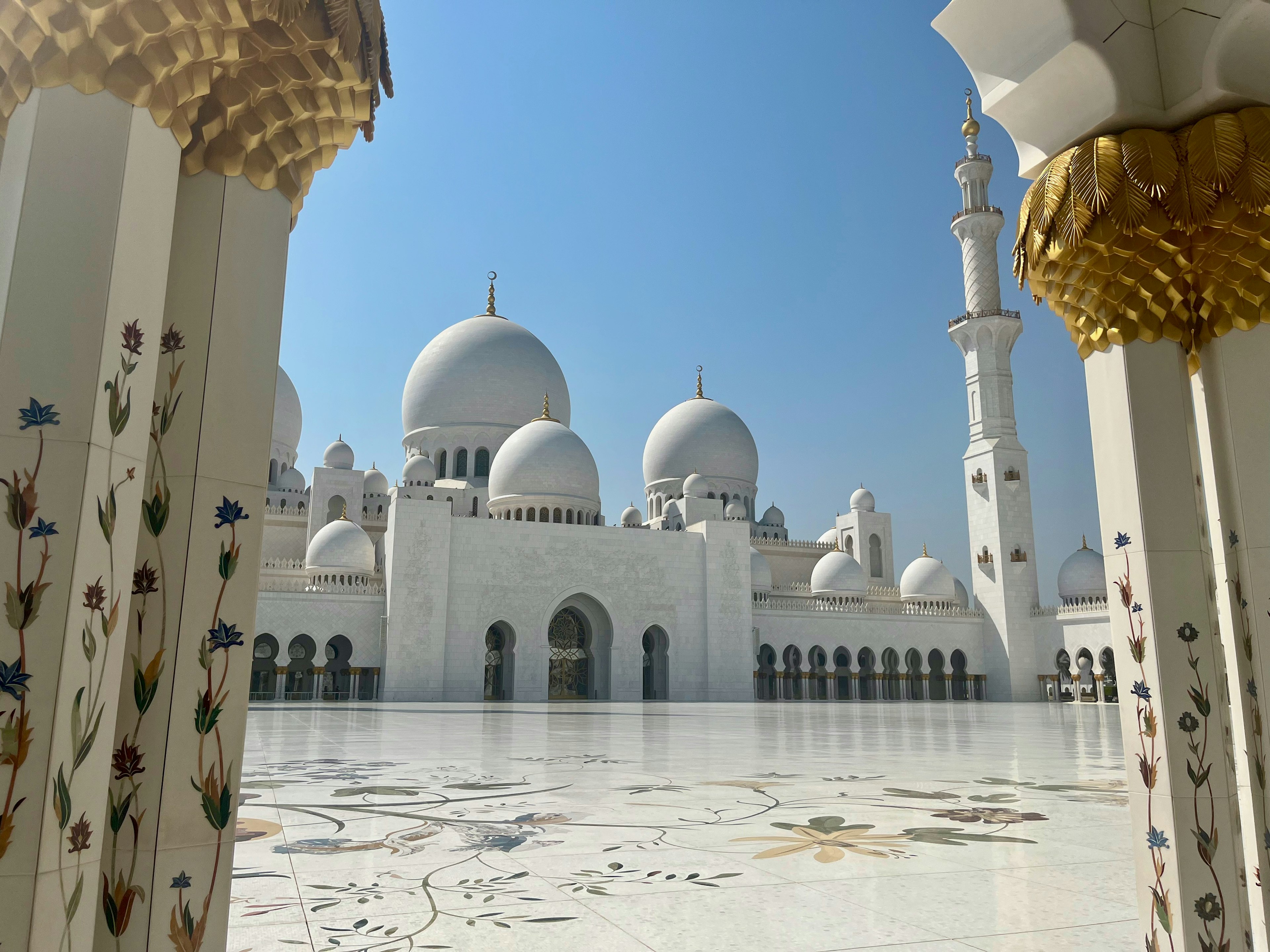 Majestätischer Blick auf die Sheikh Zayed Moschee weißer Marmorboden und blauer Himmel