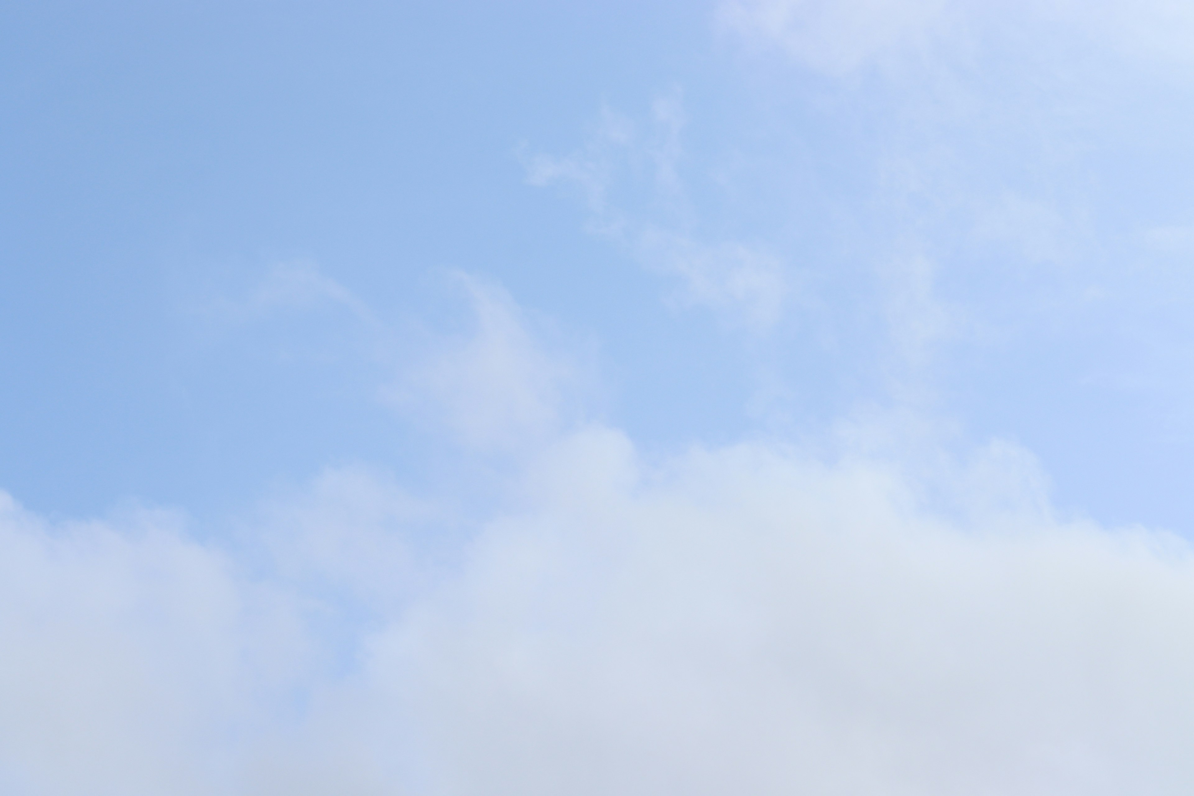 Heller blauer Himmel mit flauschigen weißen Wolken