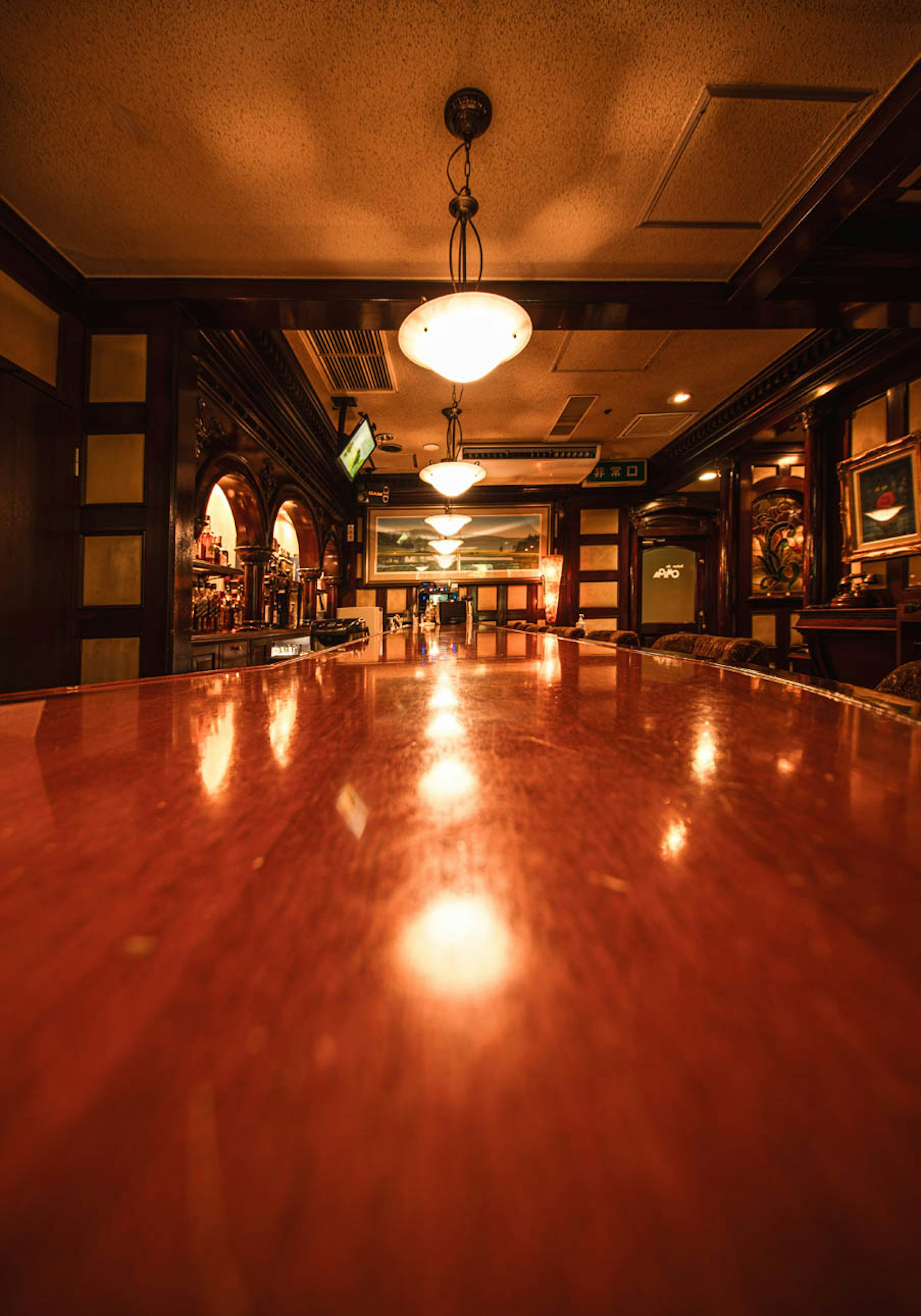 Interior of a bar featuring a wooden counter and unique lighting