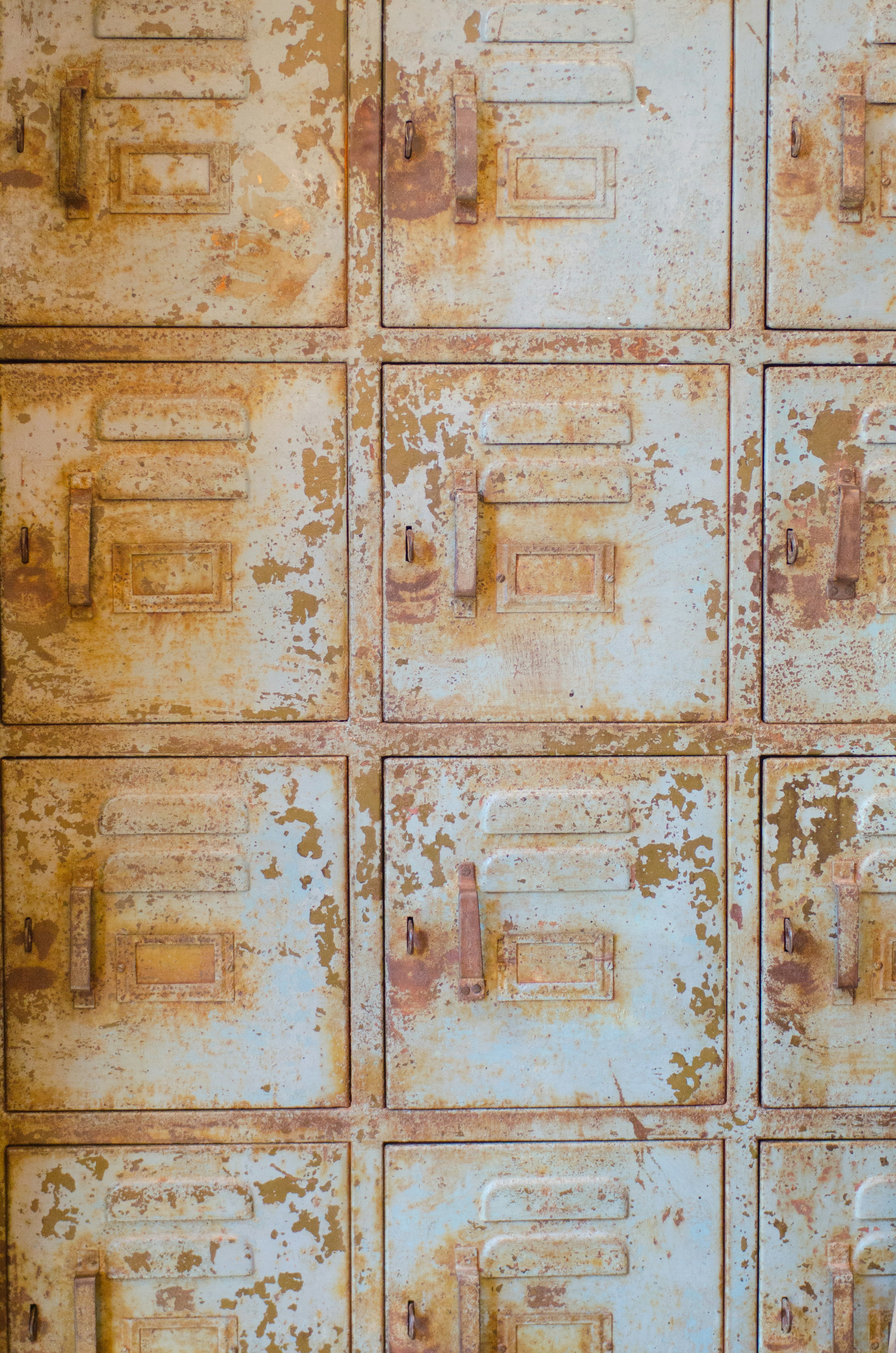 Weathered metal locker wall with rusted colors and peeling paint texture