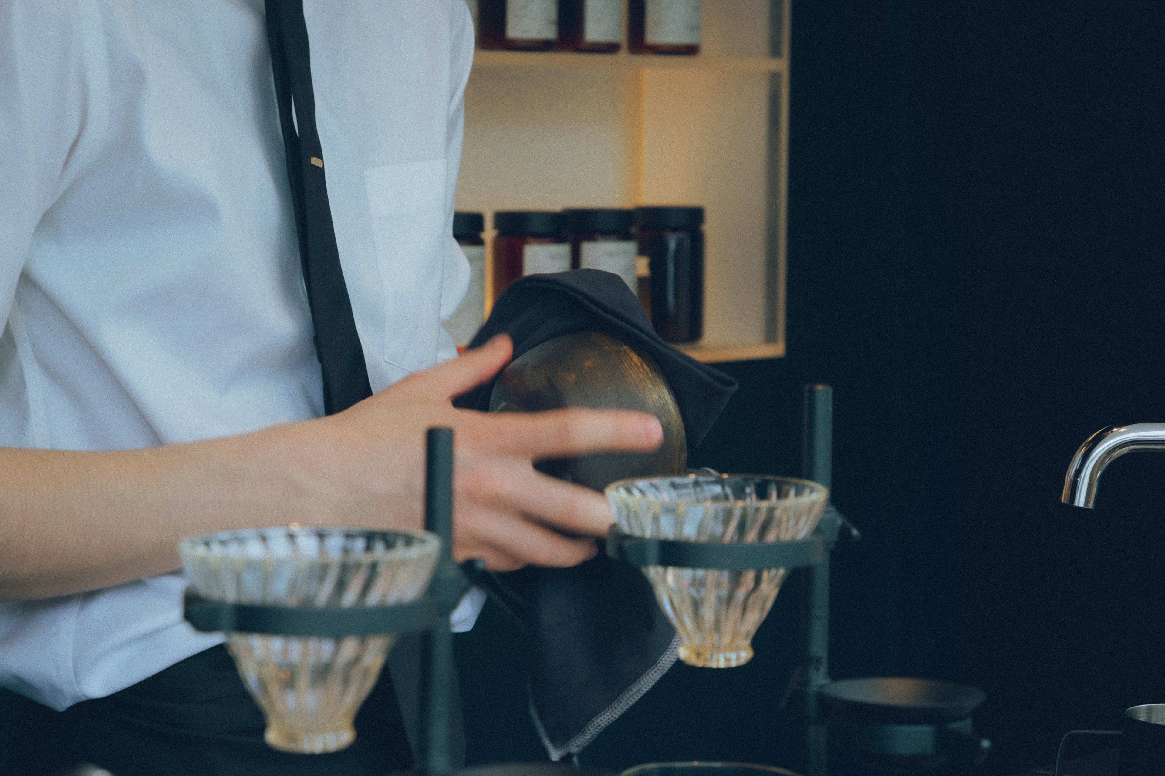 Close-up of a barista preparing coffee with brewing equipment