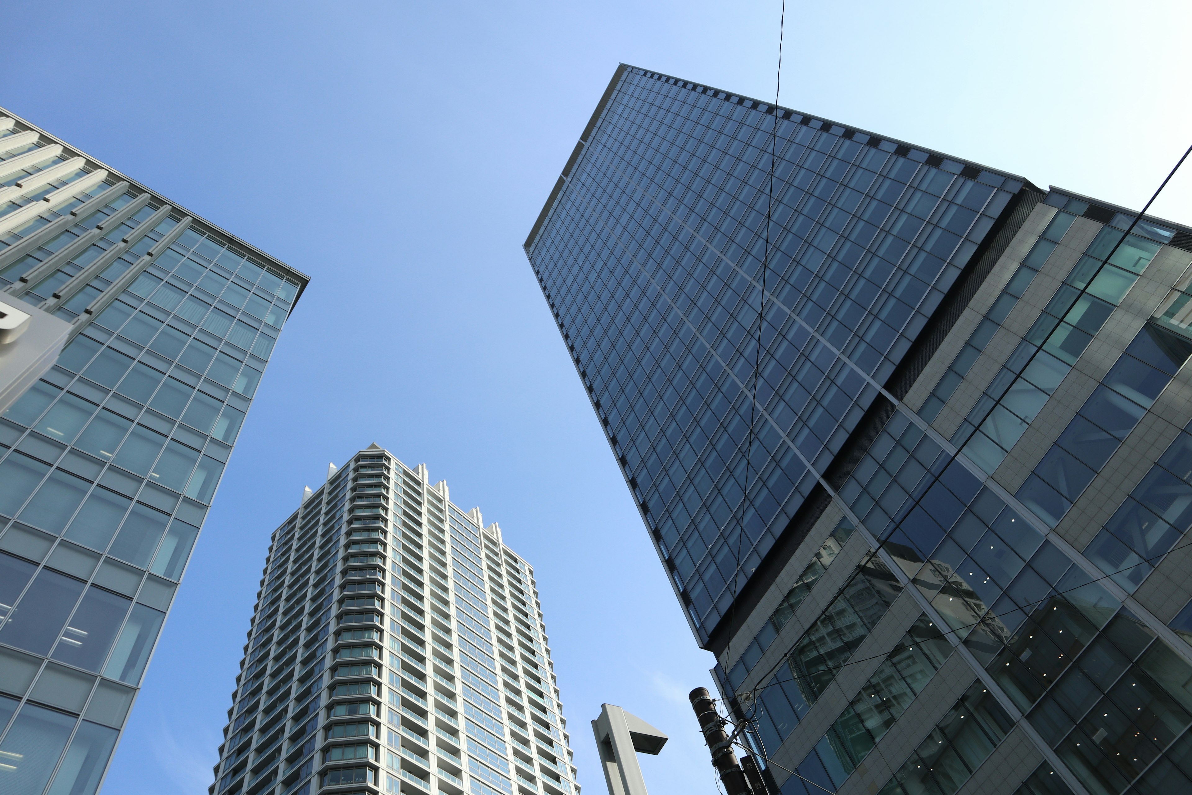 View of skyscrapers from below with clear blue sky