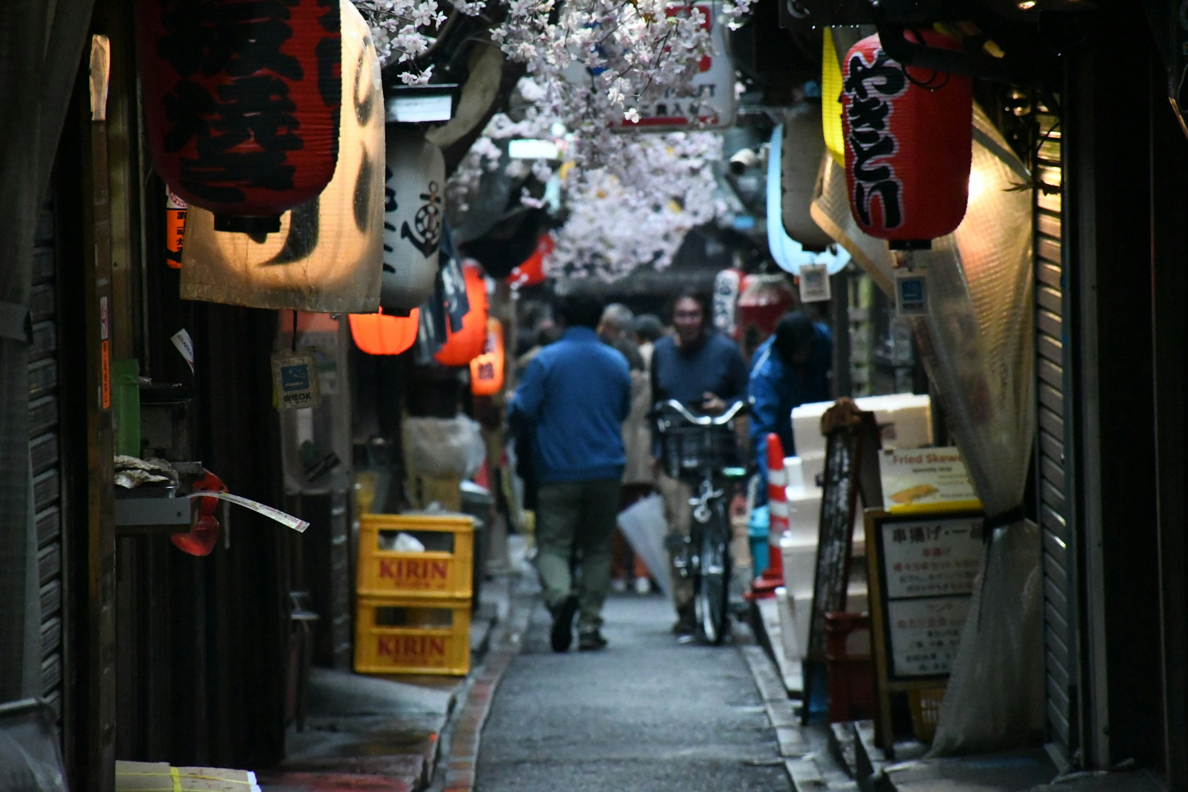 賑やかな路地に人々が集まり食べ物の屋台が並ぶ風景