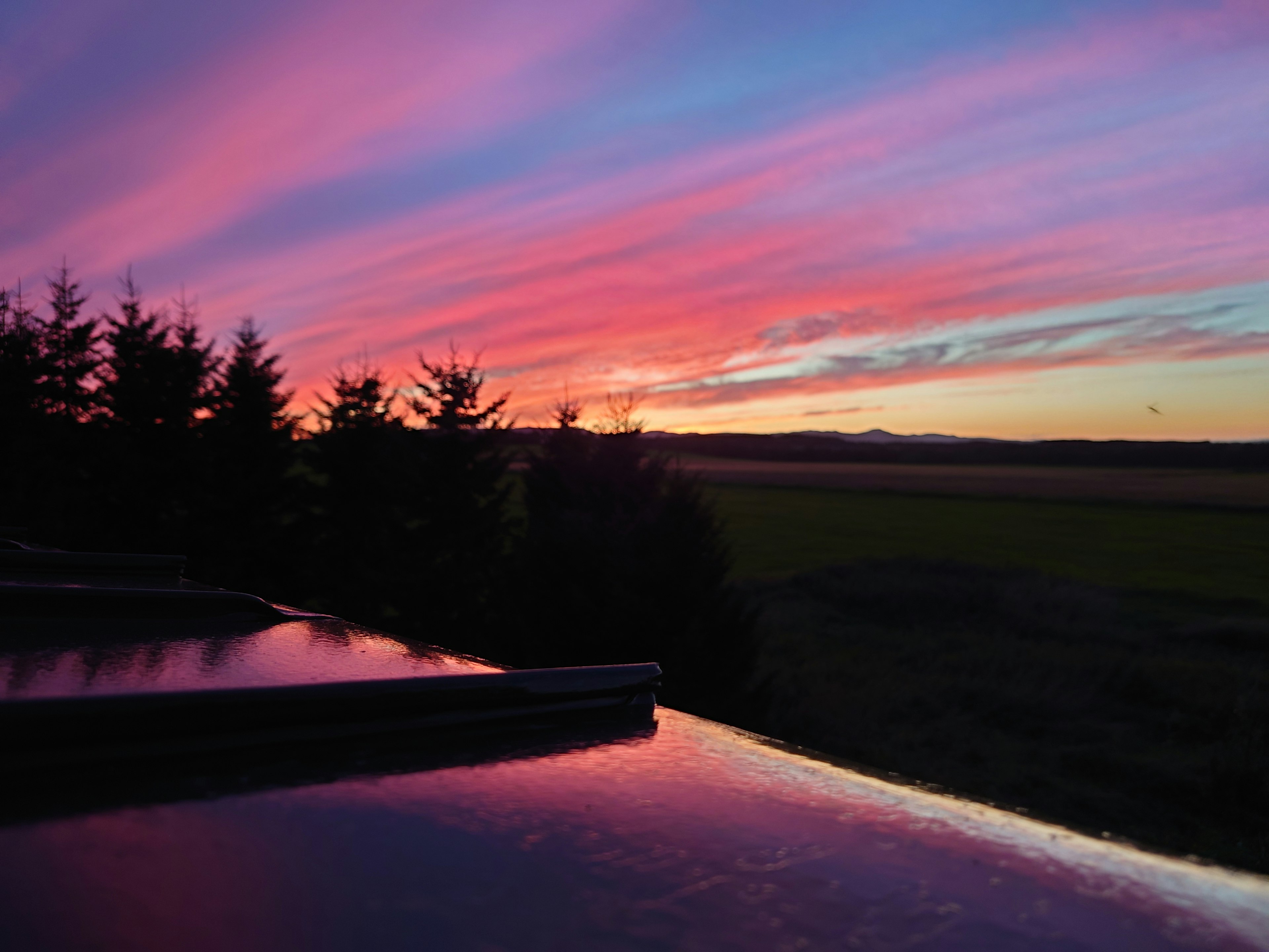 Impresionante atardecer con nubes rosas y moradas reflejadas en el agua