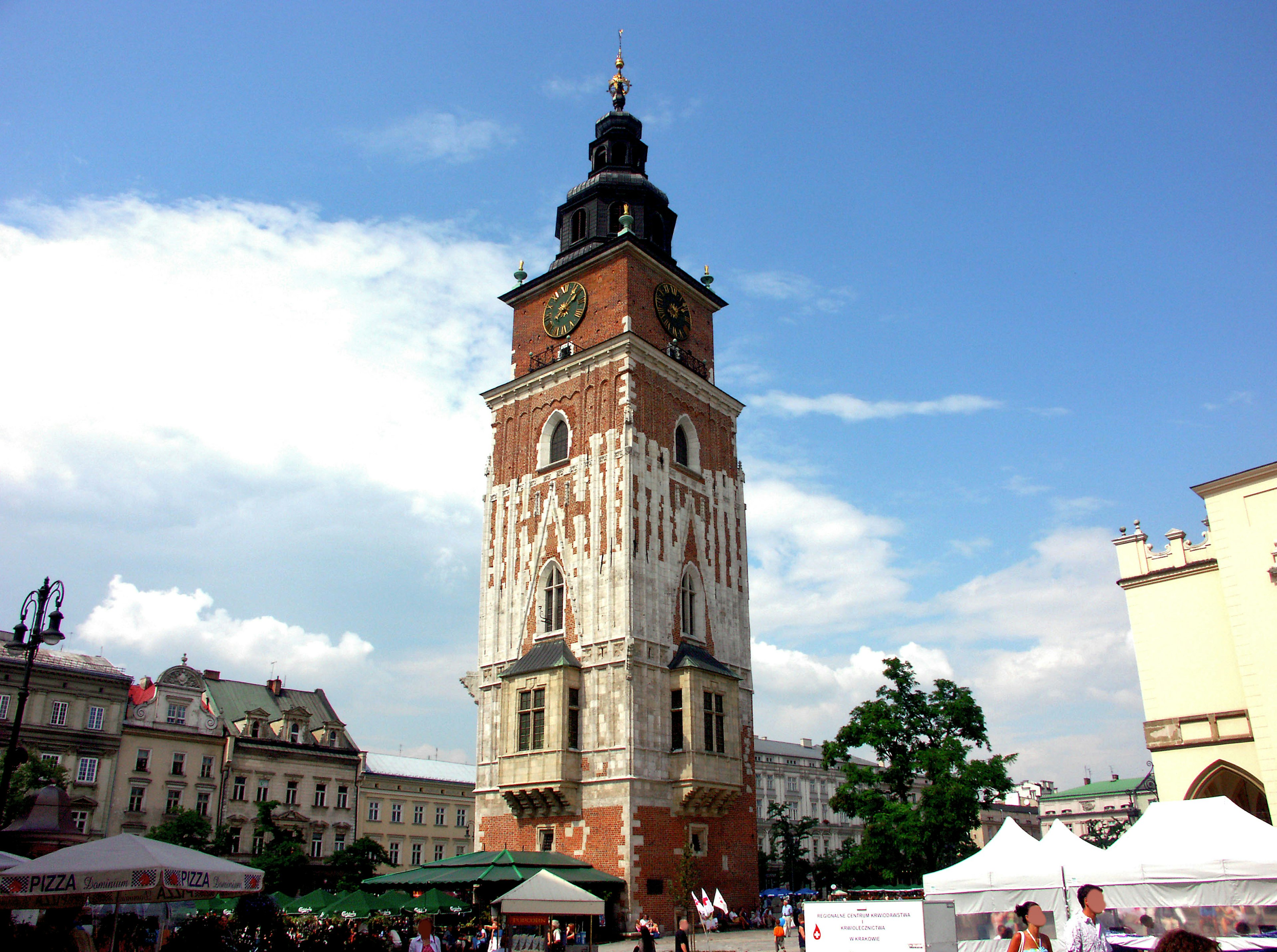 Torre storica nella piazza del mercato di Cracovia con cielo blu e nuvole bianche