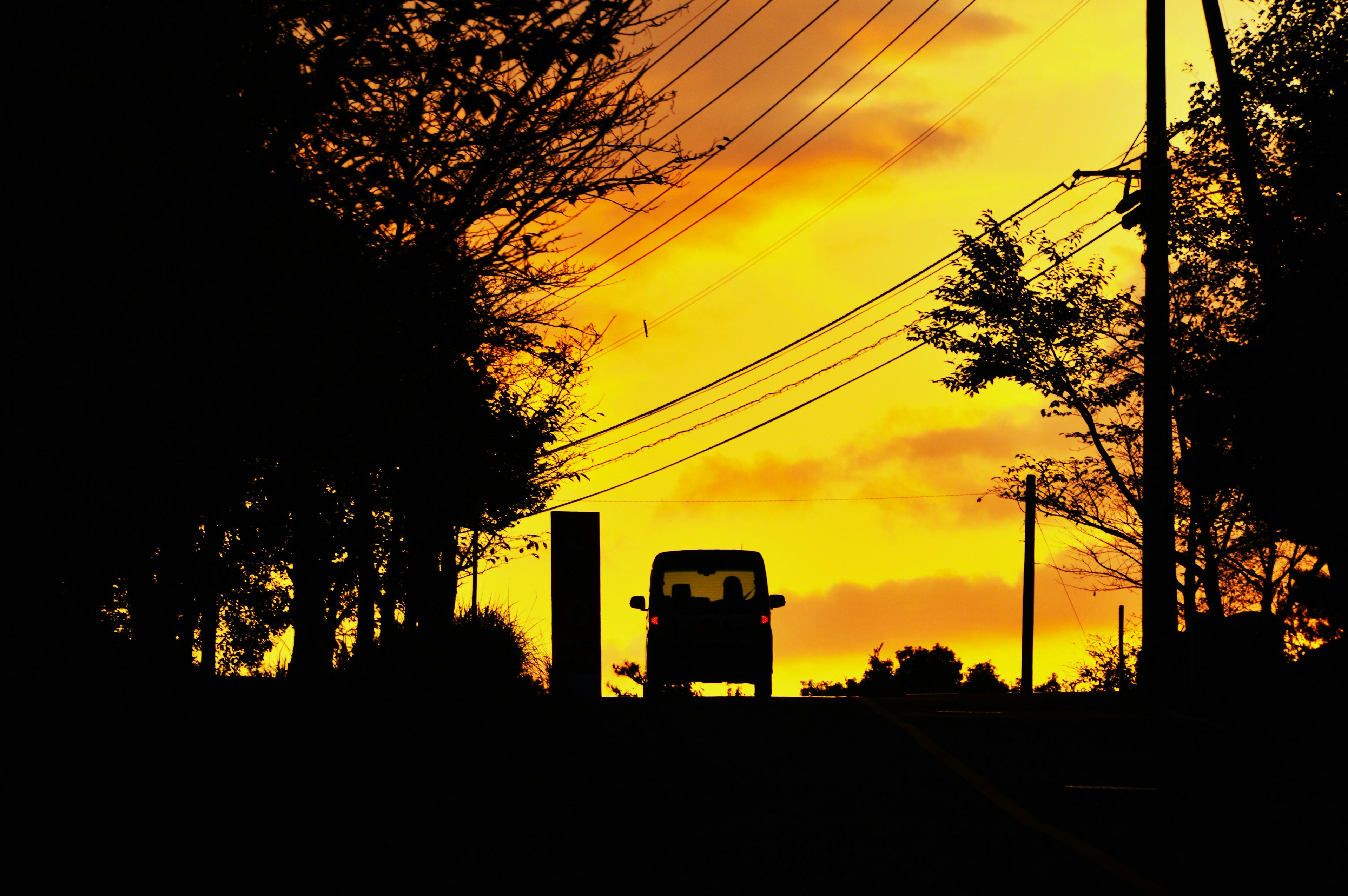 Silueta de un coche contra un vibrante atardecer