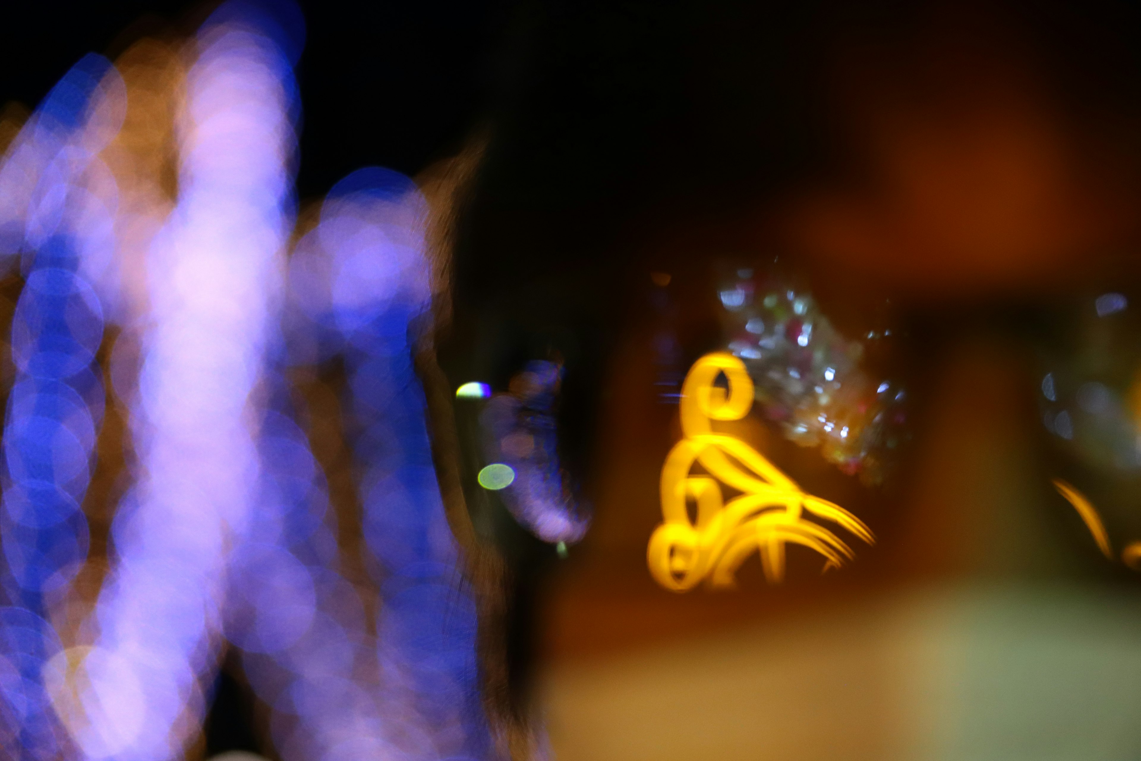 Blurred background with glowing blue lights and yellow decorations reflected in glasses