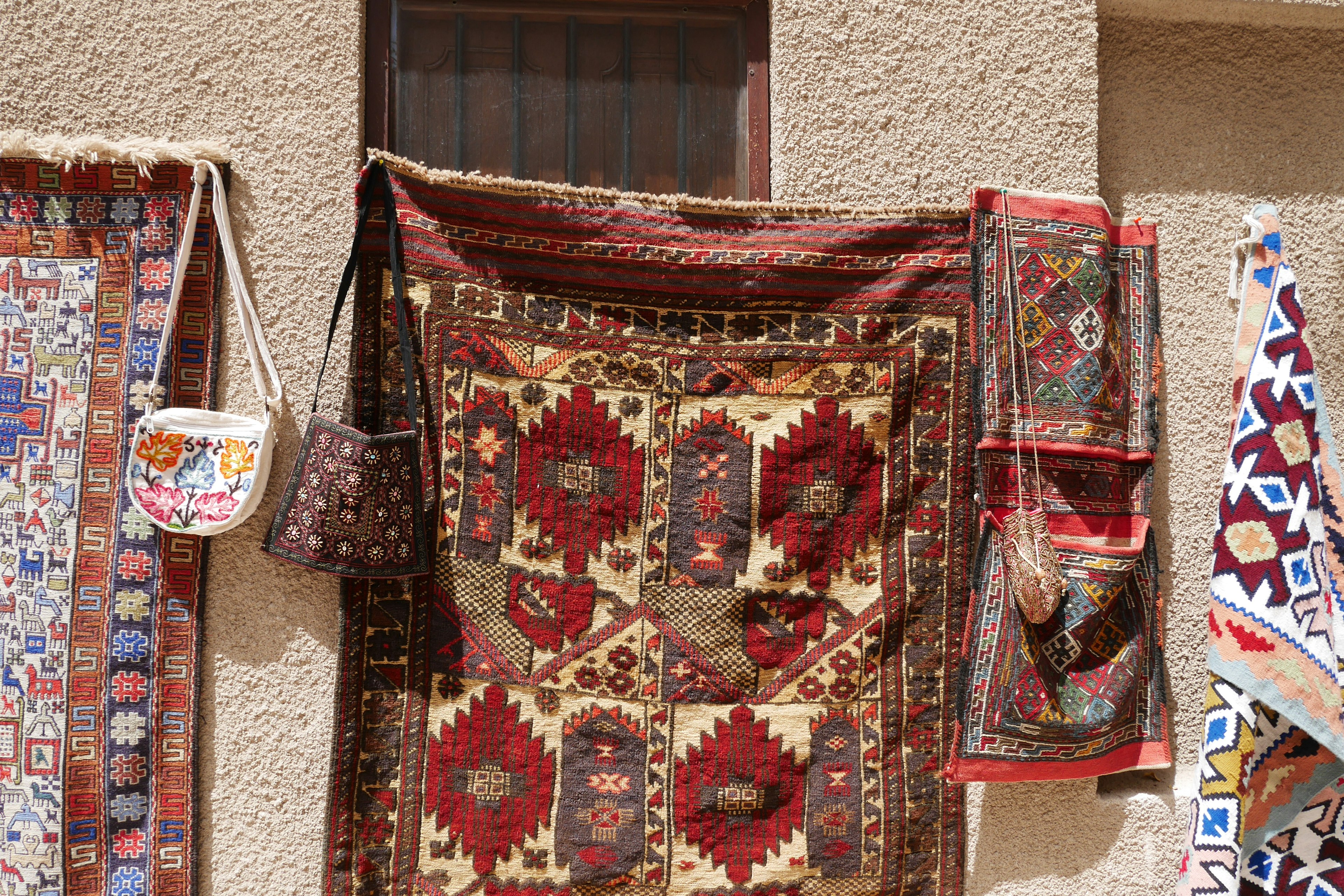 Alfombras y bolsas tradicionales coloridas colgadas en una pared